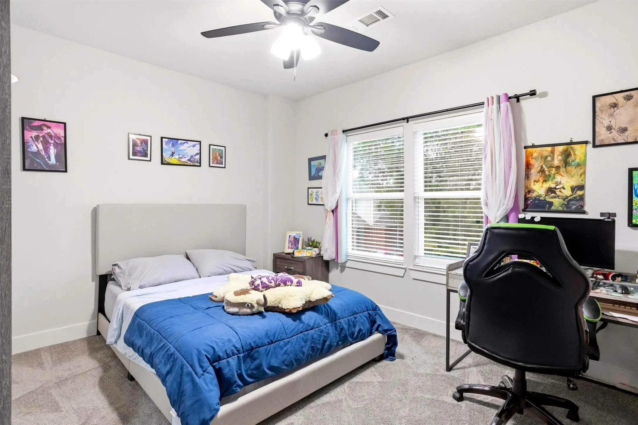 Bedroom with a desk, light colored carpet, and ceiling fan