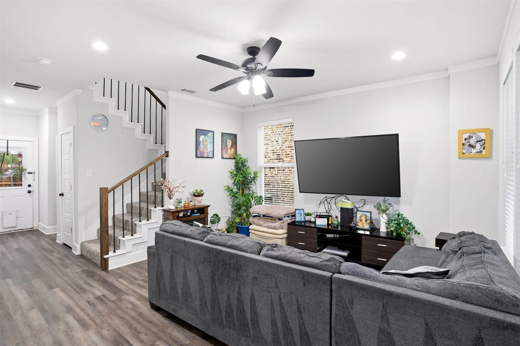 Living area featuring ceiling fan, ornamental molding, dark wood-style flooring, recessed lighting, and healthy amount of natural light