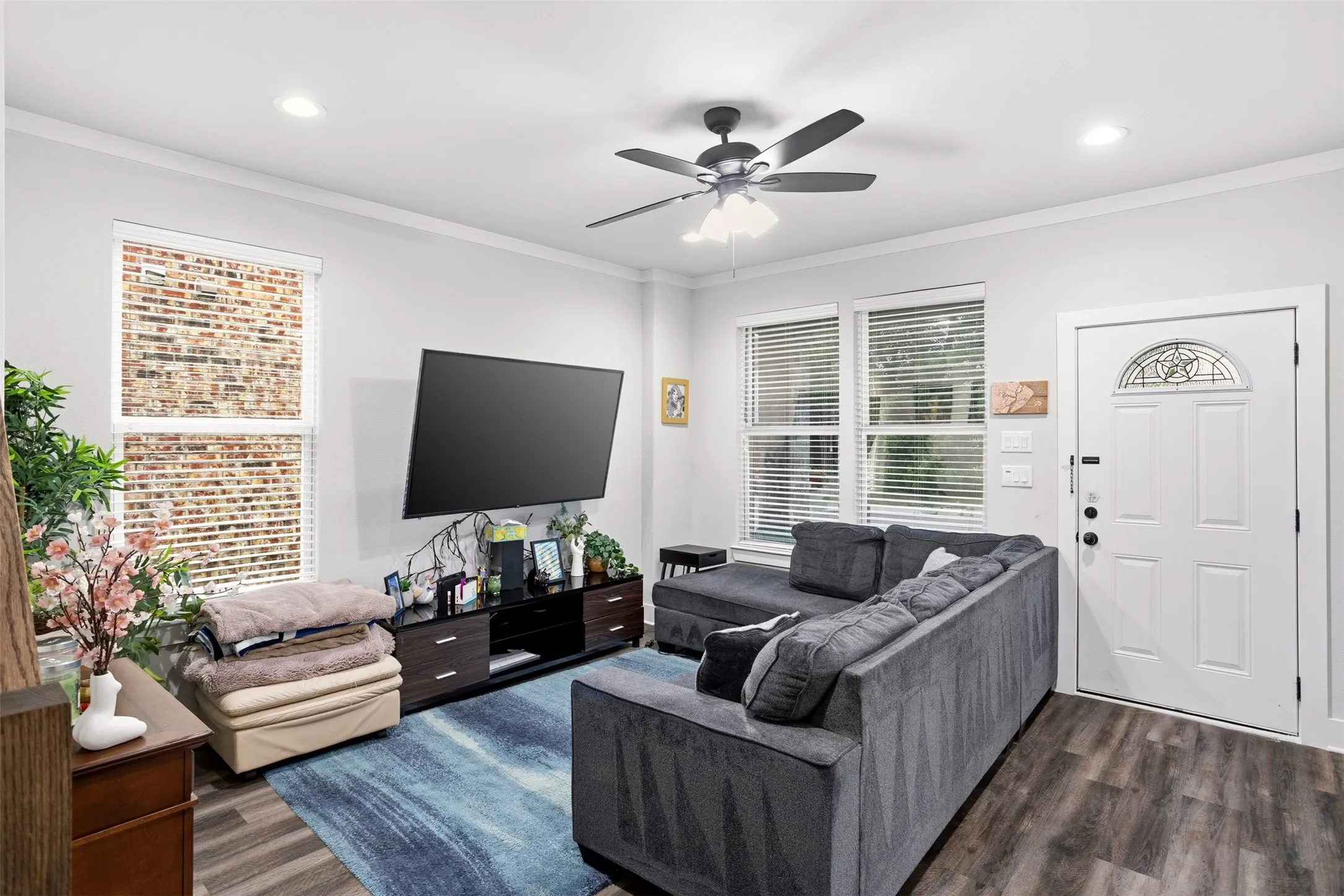 Living room with crown molding, dark wood-type flooring, ceiling fan, and recessed lighting