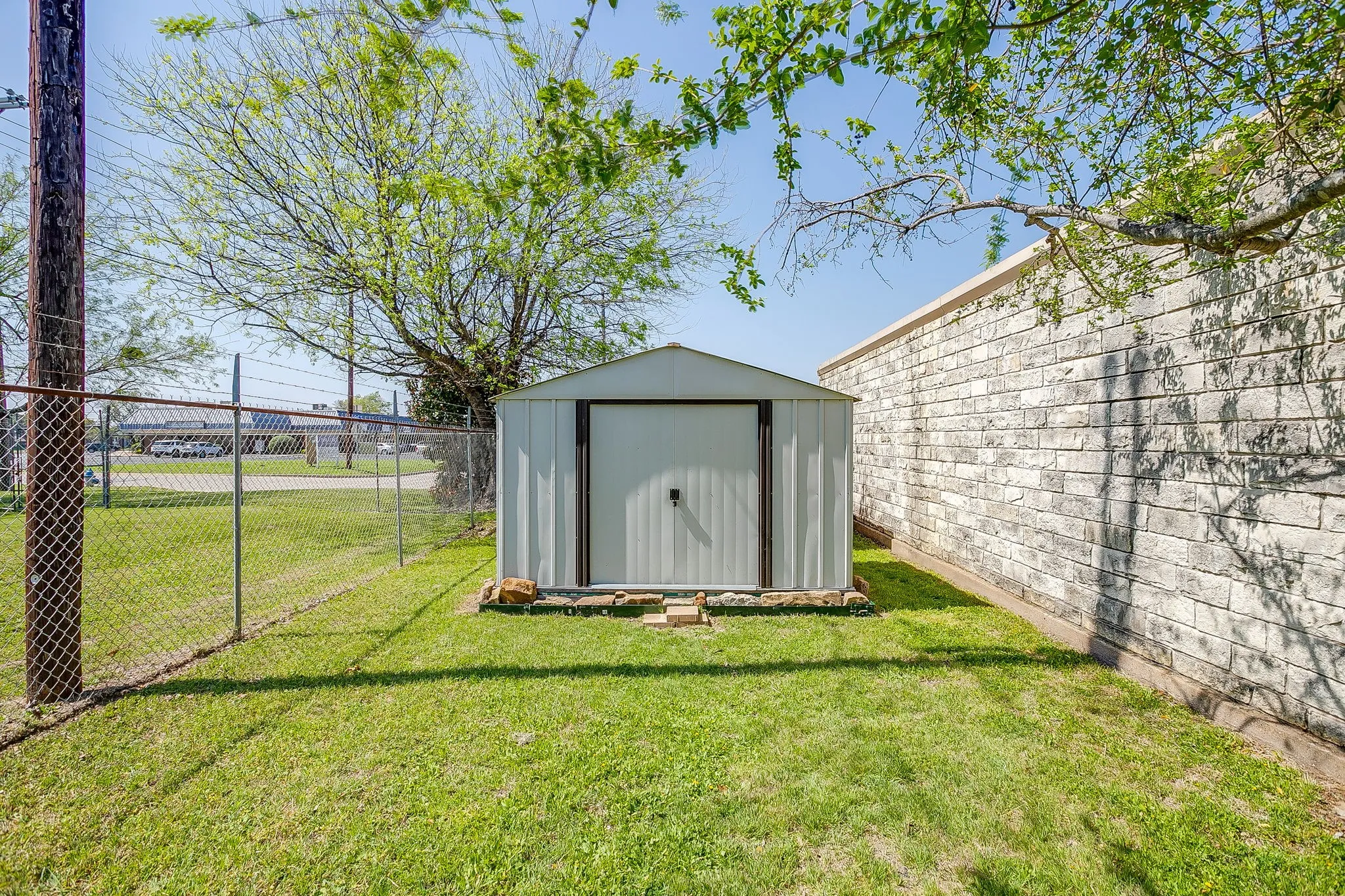 This small storage building in the back is secure within the gated & fenced area and will stay with the building.