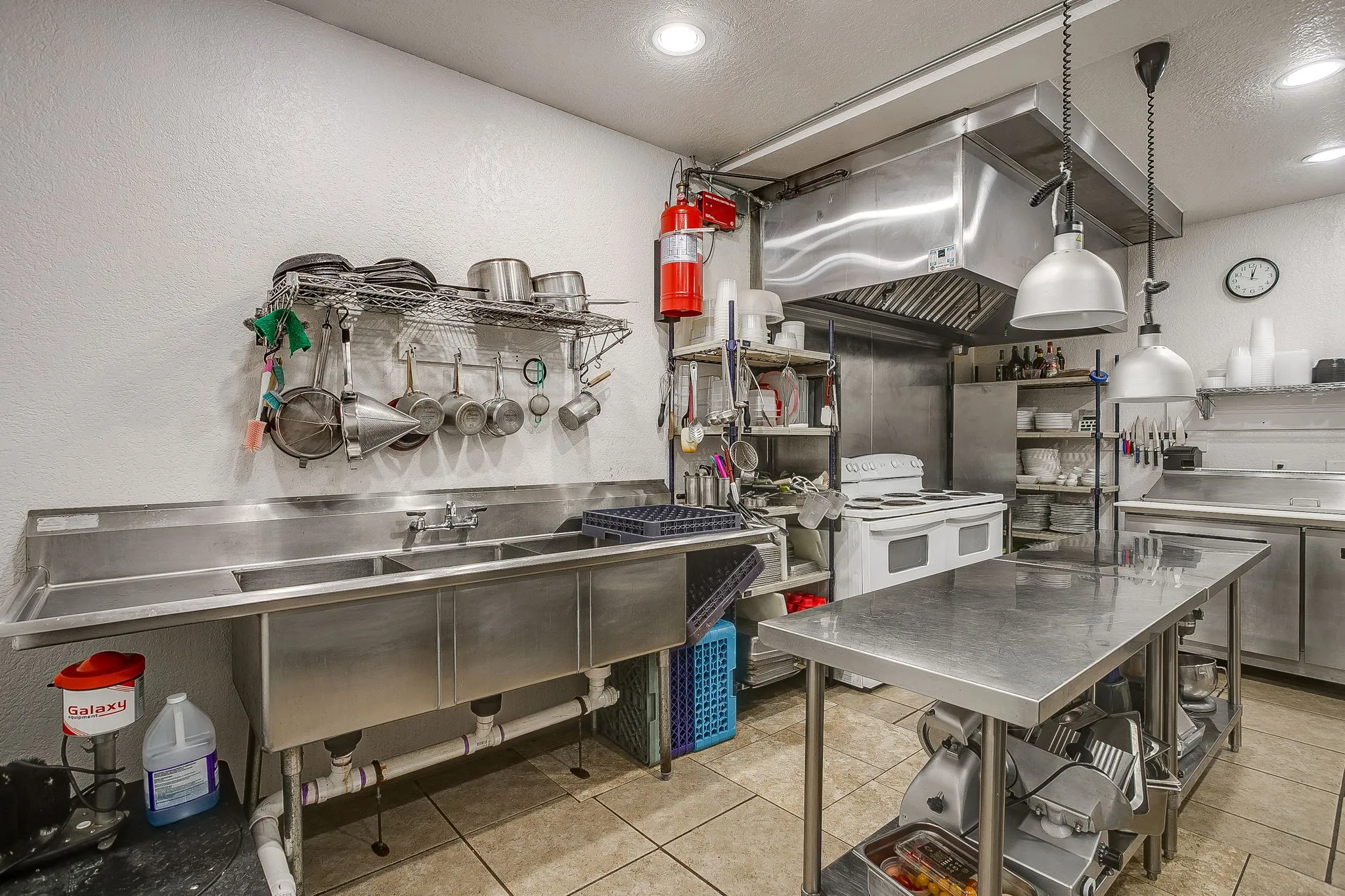 A full sink and dish washing area.
