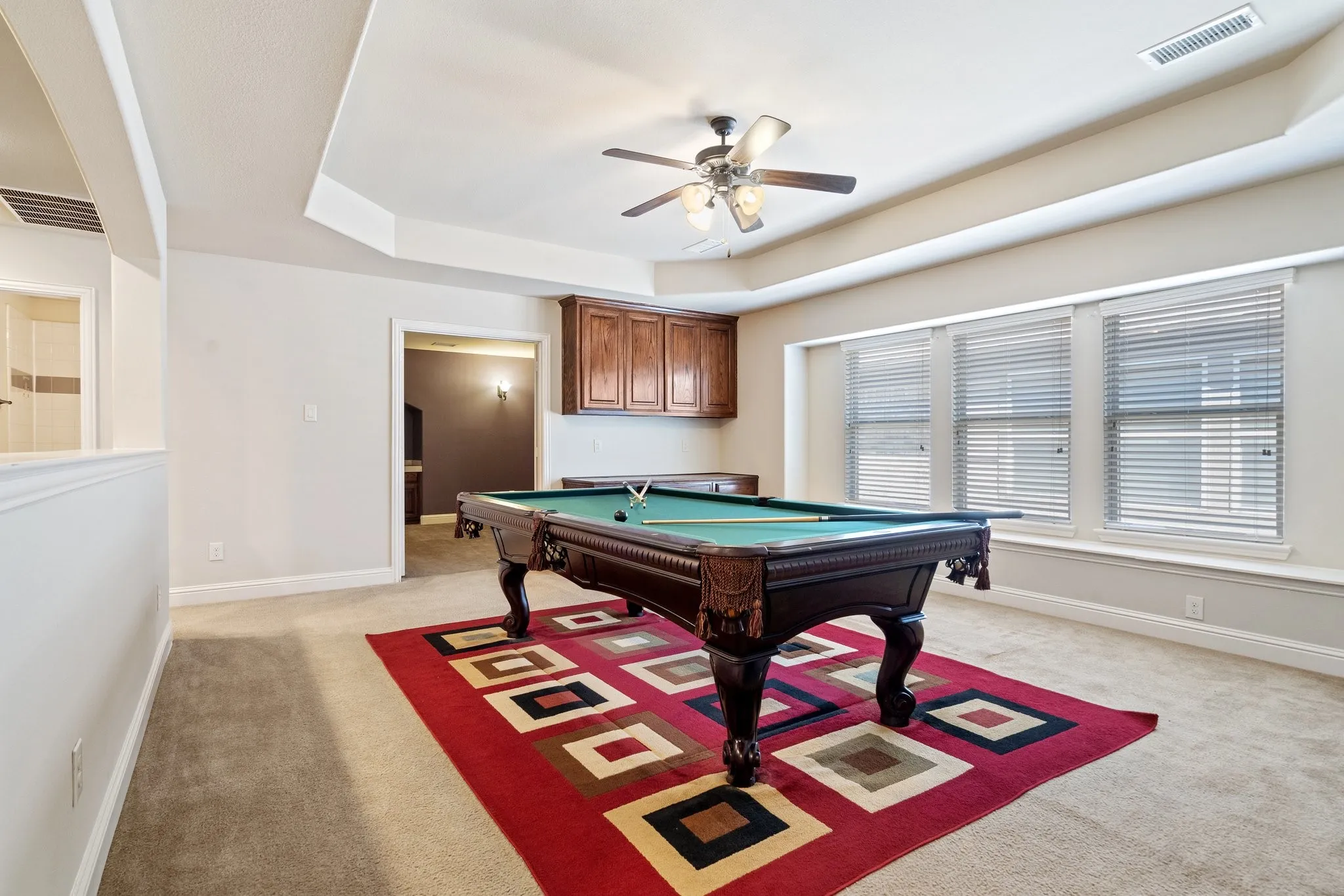 Huge game room with luxurious tray ceilings and sitting space by the windows. Pool Table negotiable