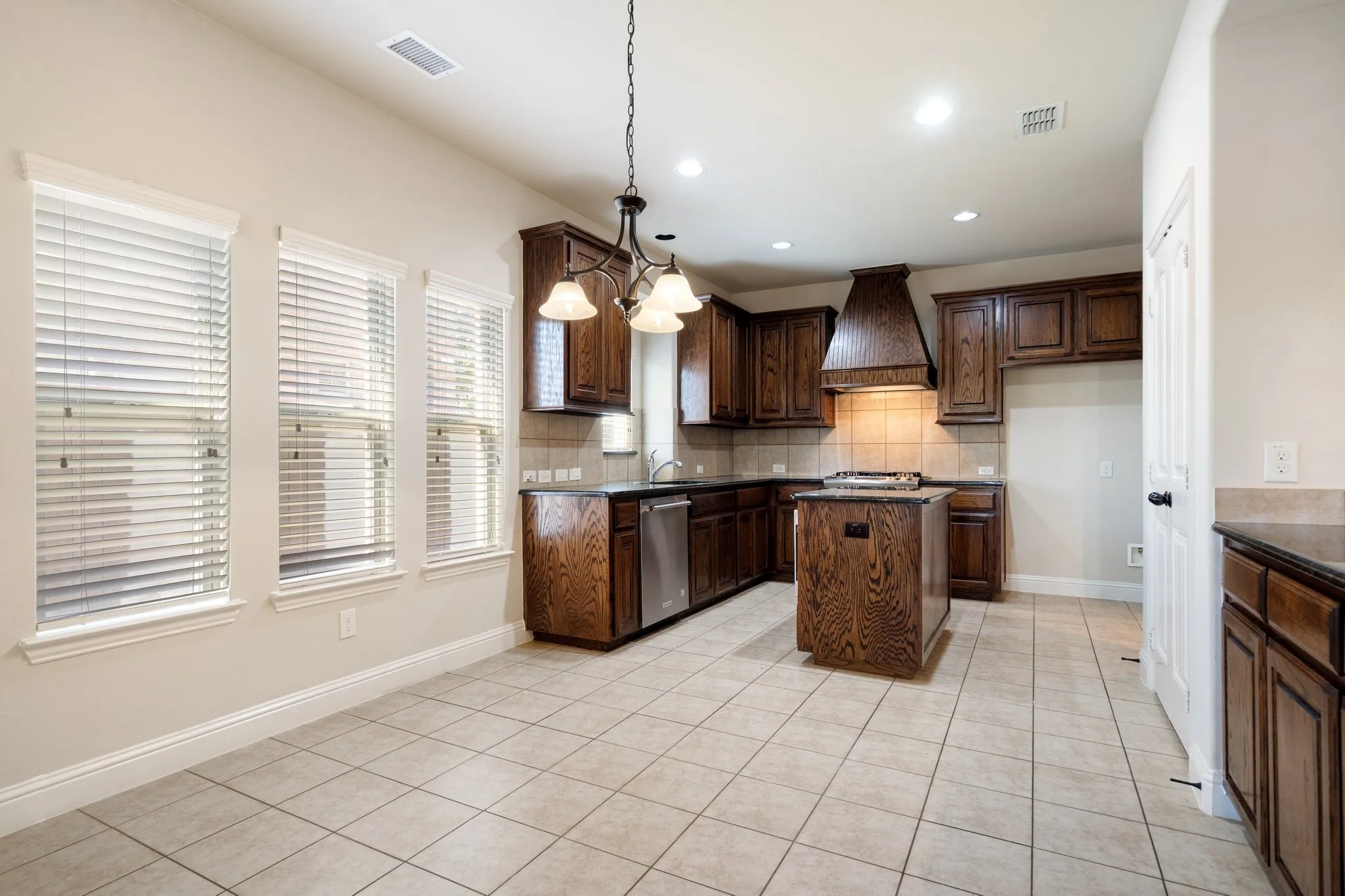 Rich, custom-stained wood cabinets offer not only abundant storage but also timeless elegance