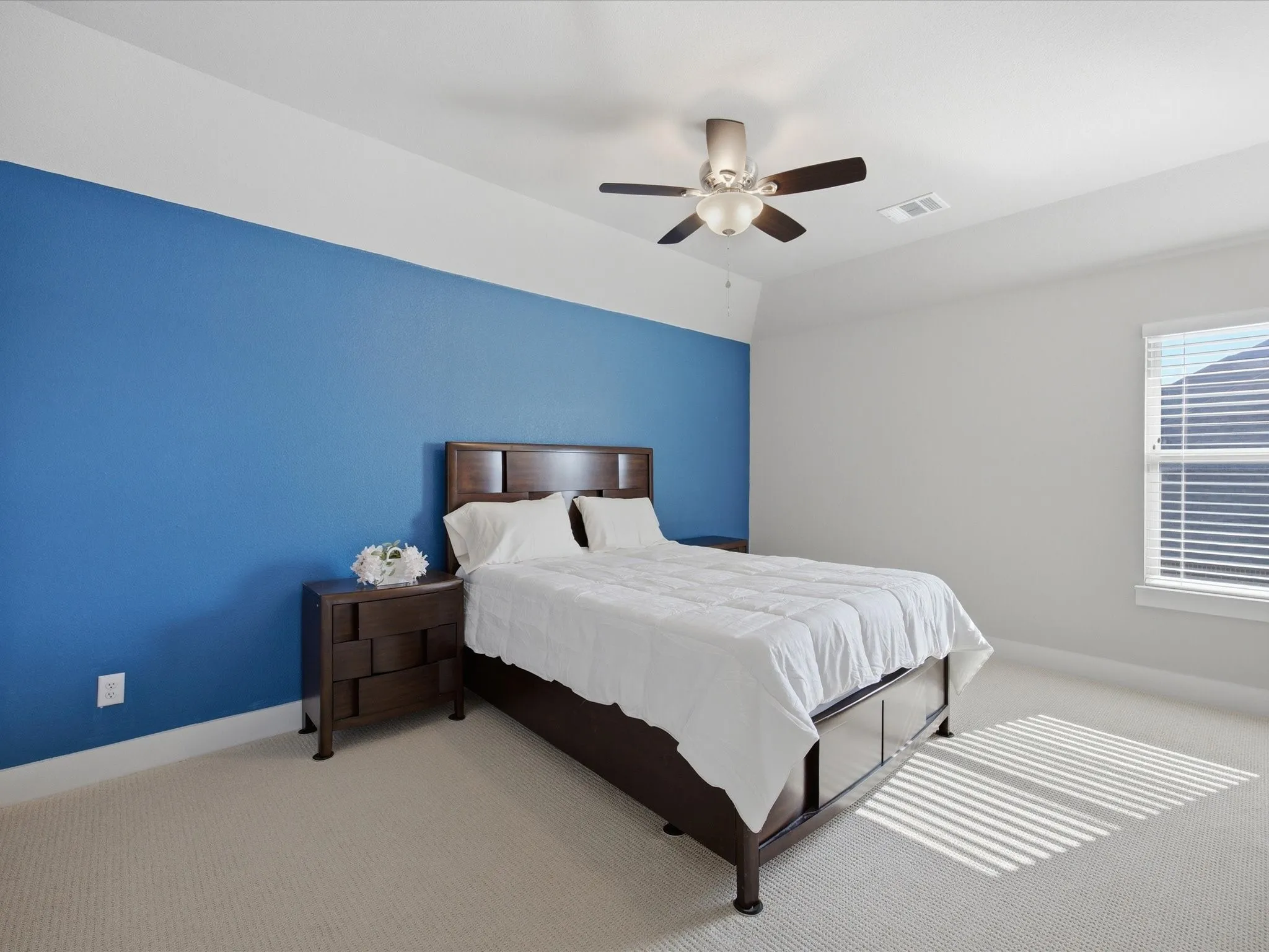 Carpeted bedroom featuring baseboards and a ceiling fan