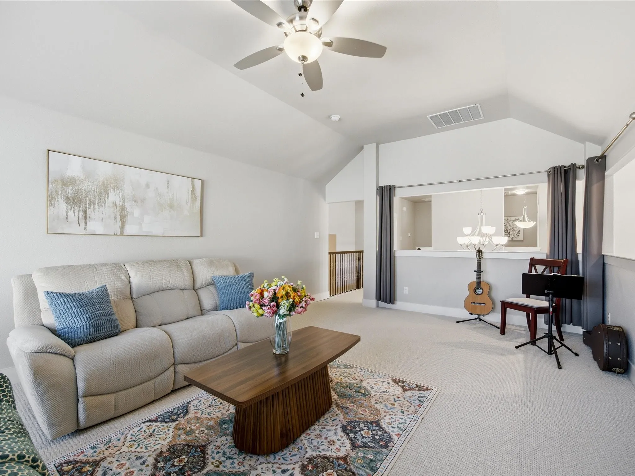 Upstairs carpeted living room with ceiling fan and baseboards