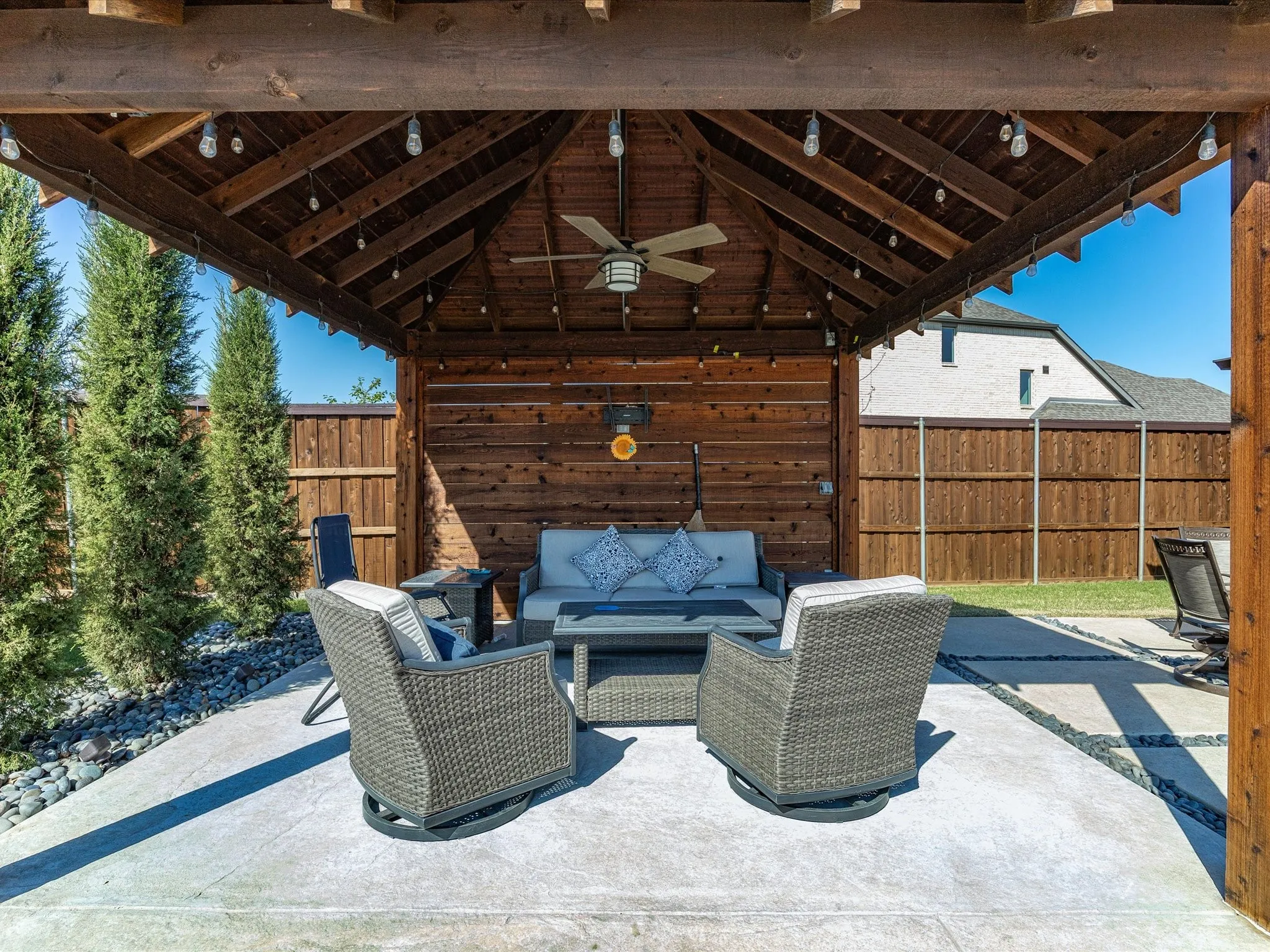 Fenced backyard featuring outdoor lounge area, ceiling fan, and a patio