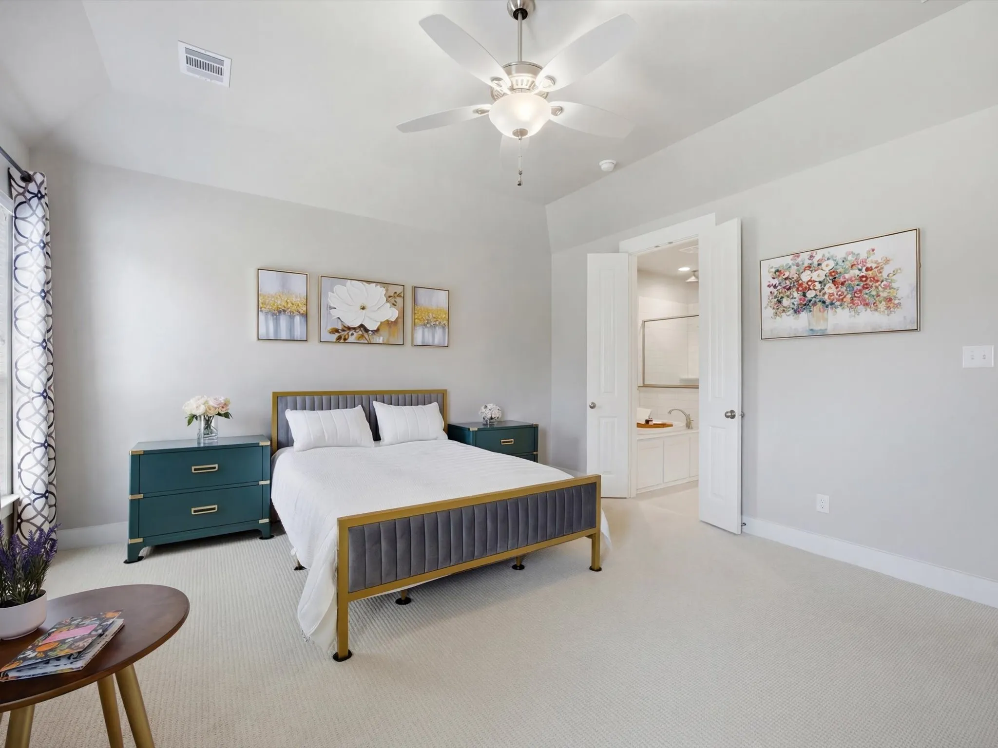 Bedroom with light carpet, a ceiling fan, and ensuite bath