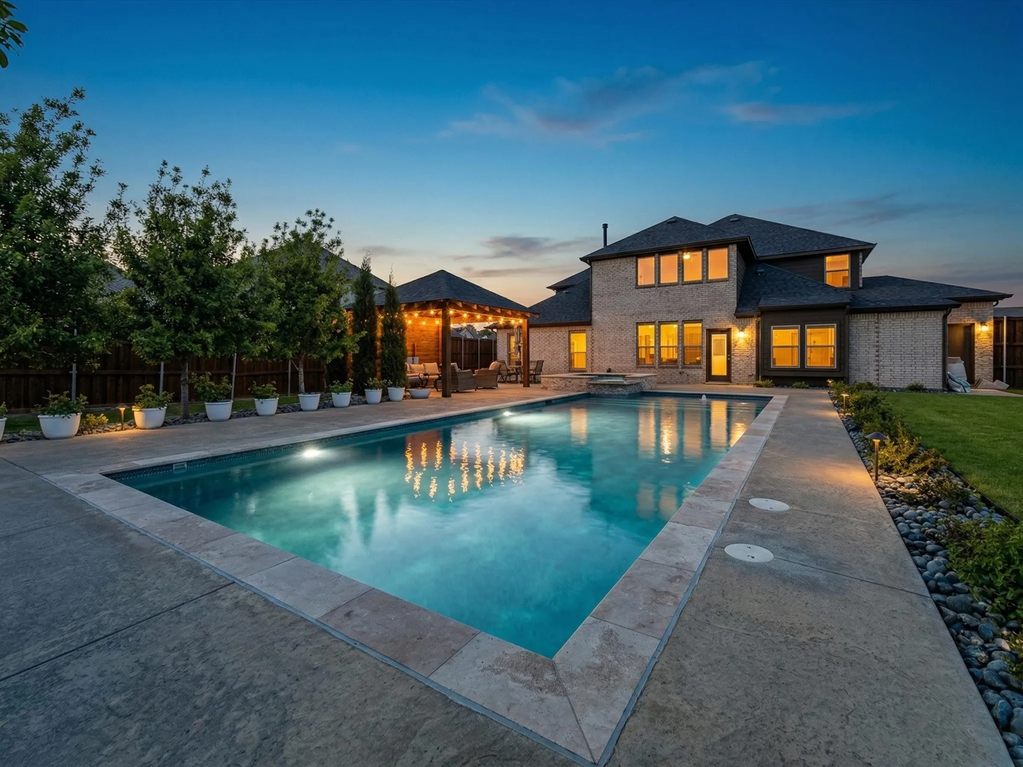 Combined pool / hot tub featuring a patio area and a fenced backyard