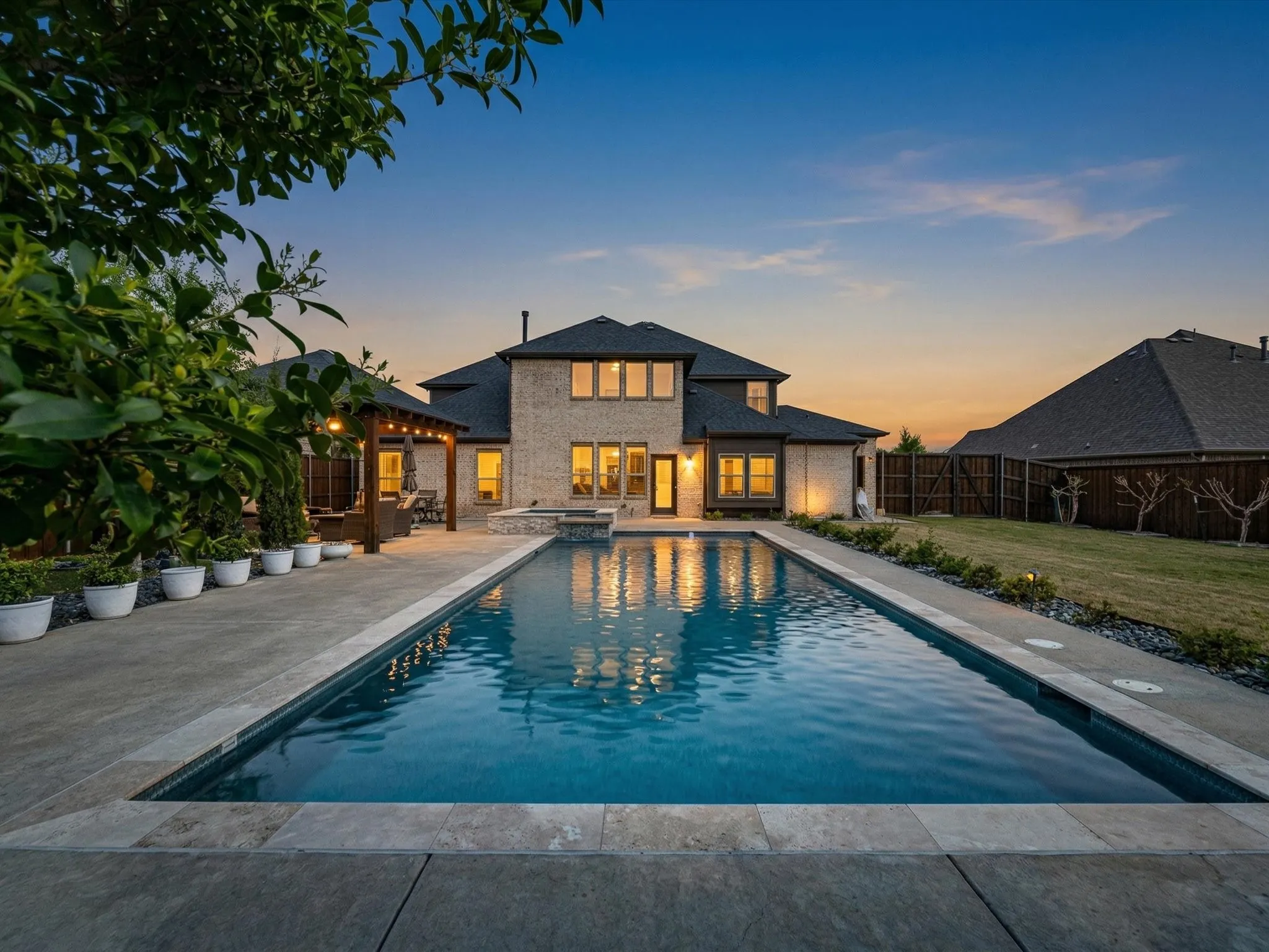 Rear view of house featuring a patio, a pool with connected hot tub, and a fenced backyard
