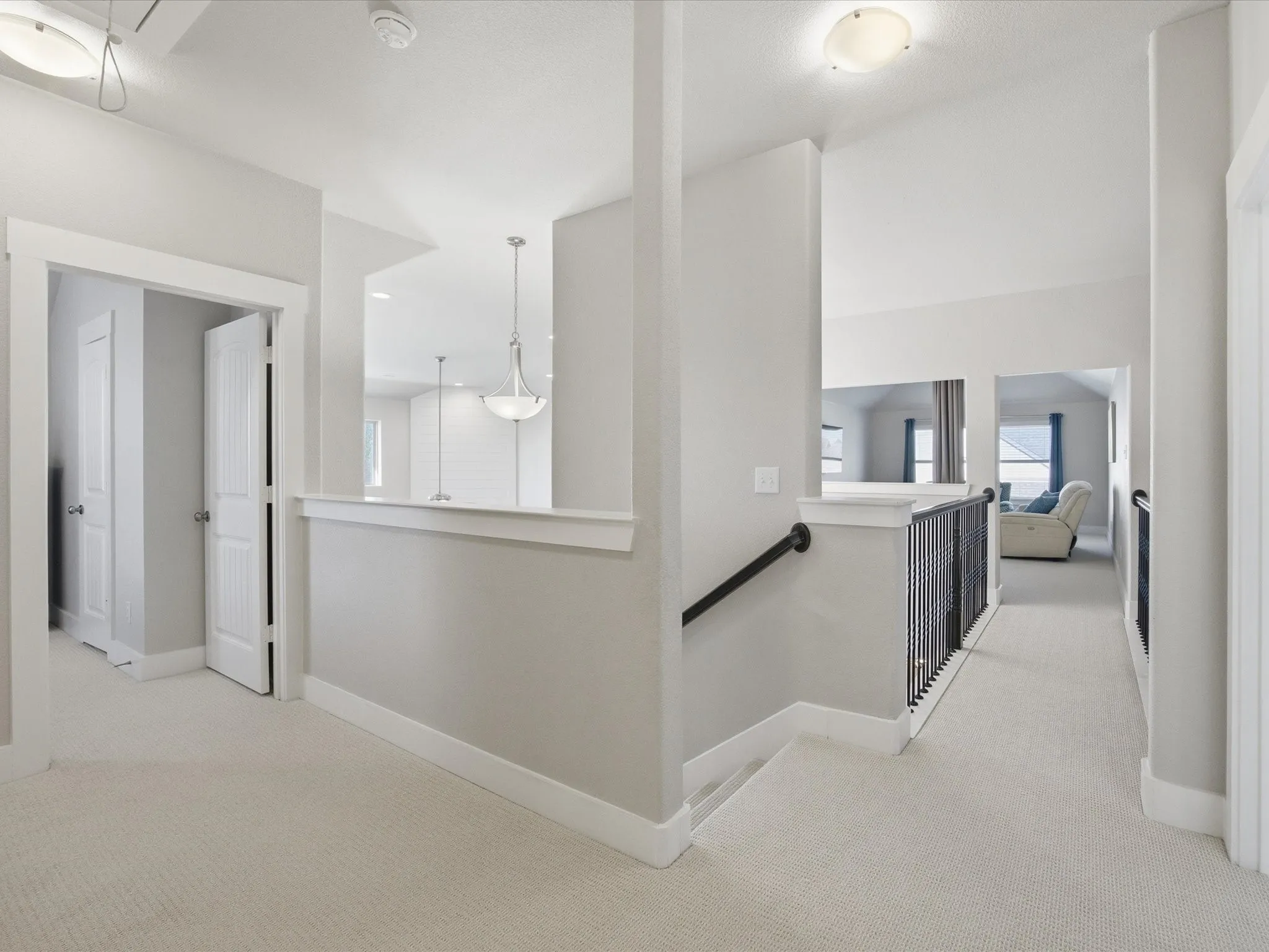 Hall featuring light carpet and an upstairs landing