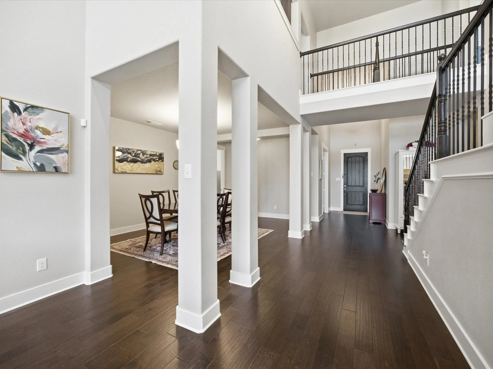 Foyer featuring dark wood-style flooring and a high ceiling