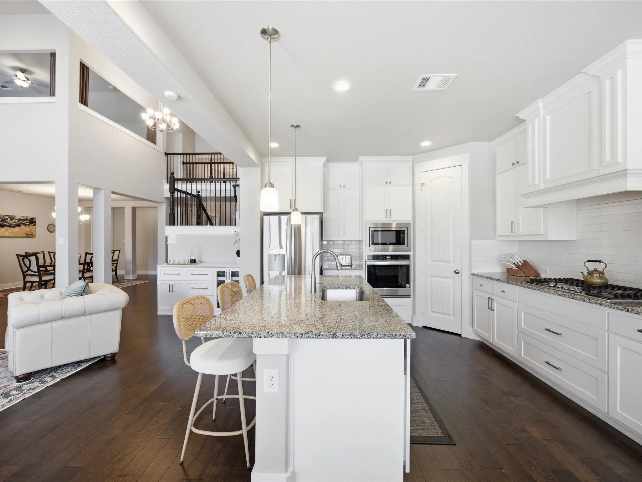 Kitchen featuring white cabinets, a breakfast bar area, light stone countertops, and a high ceiling