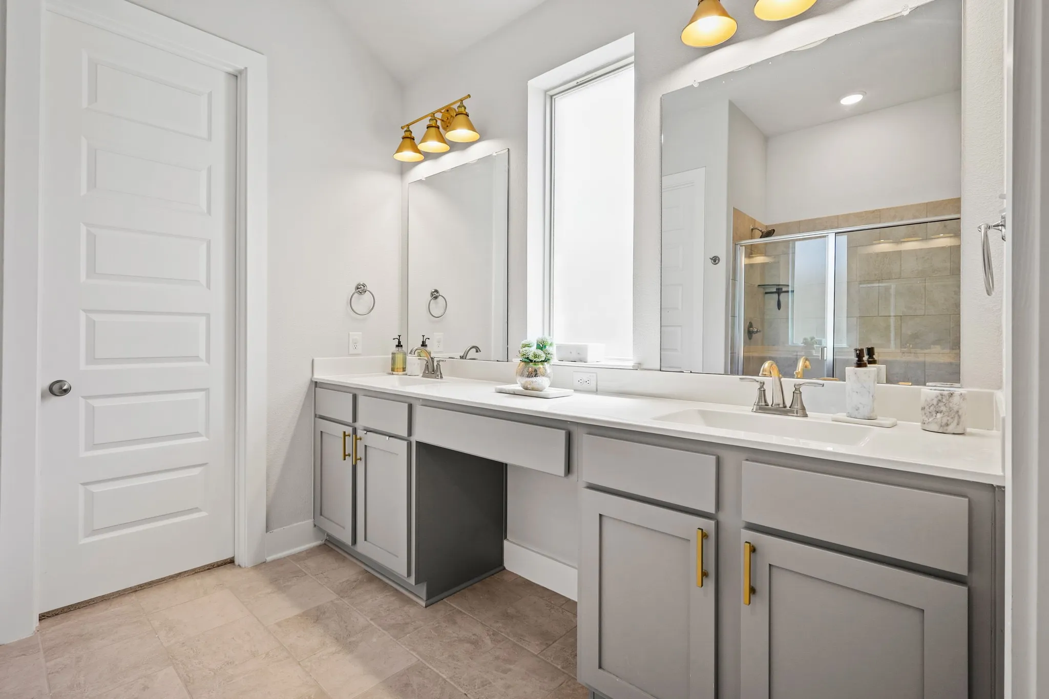 Bathroom featuring dual vanity, walk in shower, and tile patterned floors