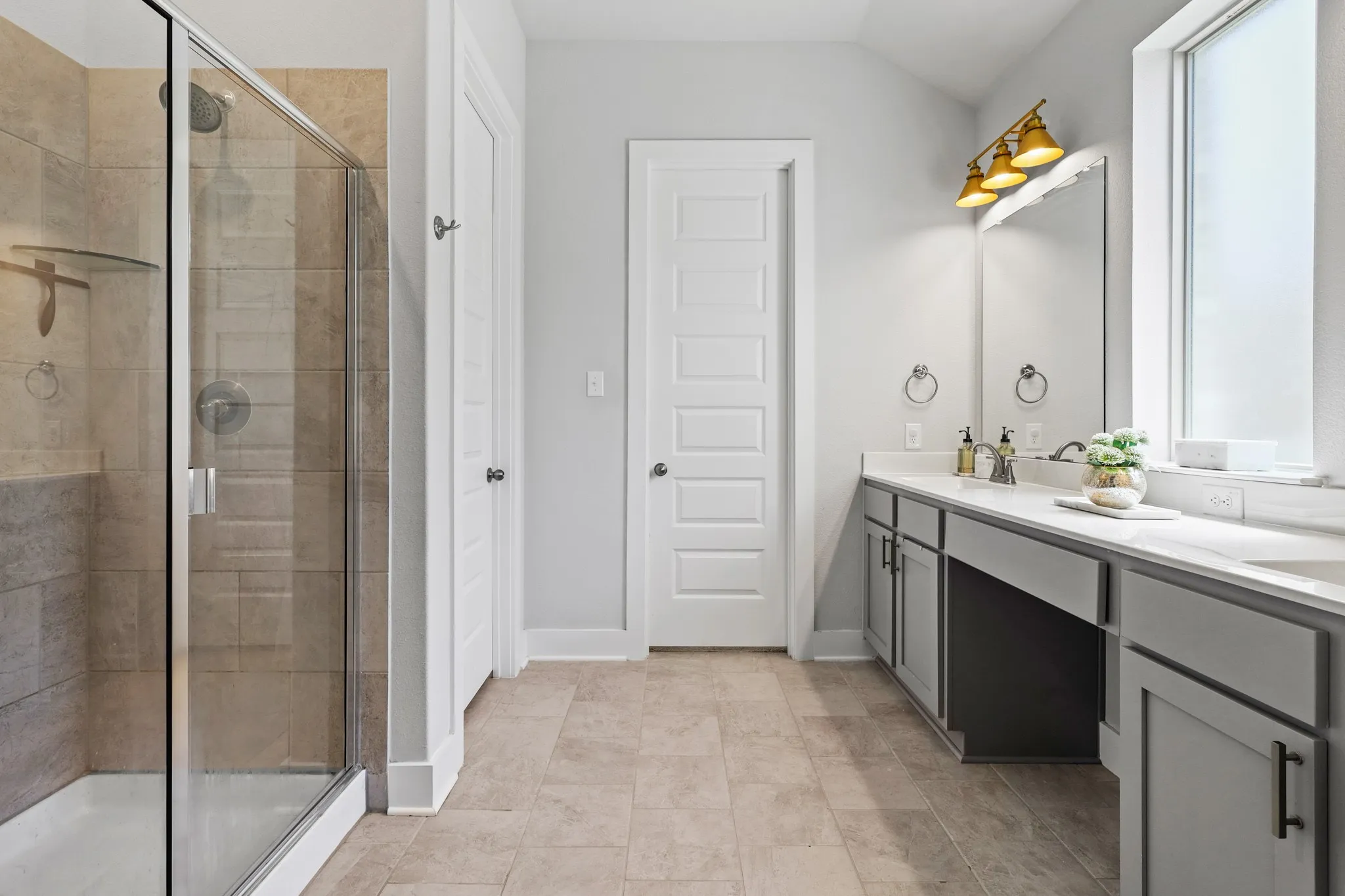 Bathroom featuring tile patterned flooring, an enclosed shower, vaulted ceiling, and vanity