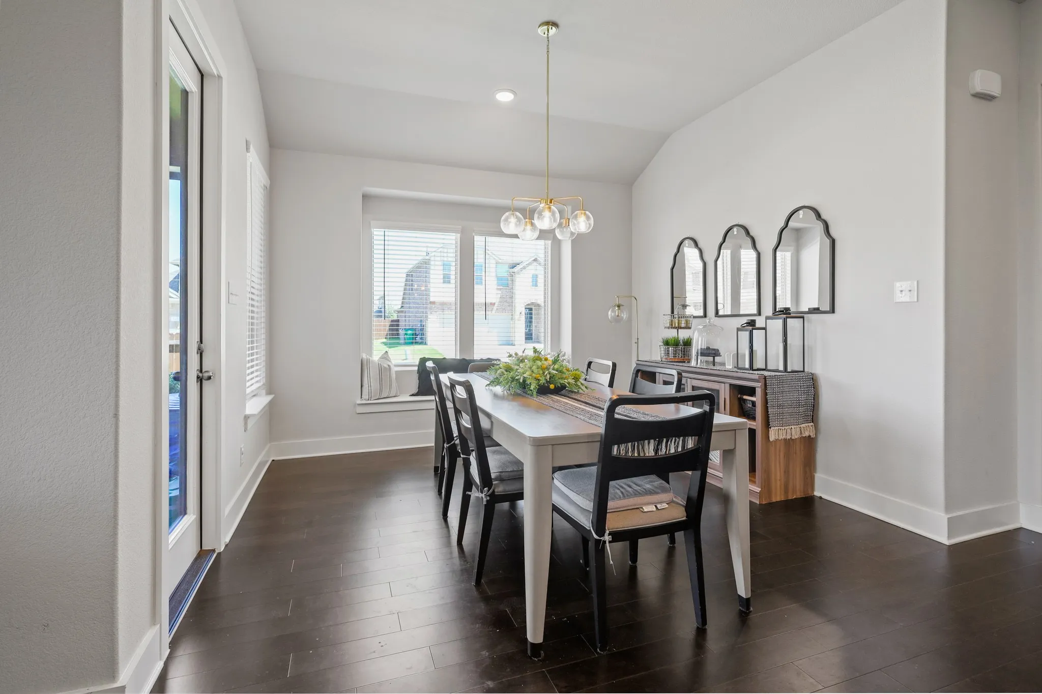 Dining room featuring vaulted ceiling, dark hardwood / wood-style flooring, and a chandelier