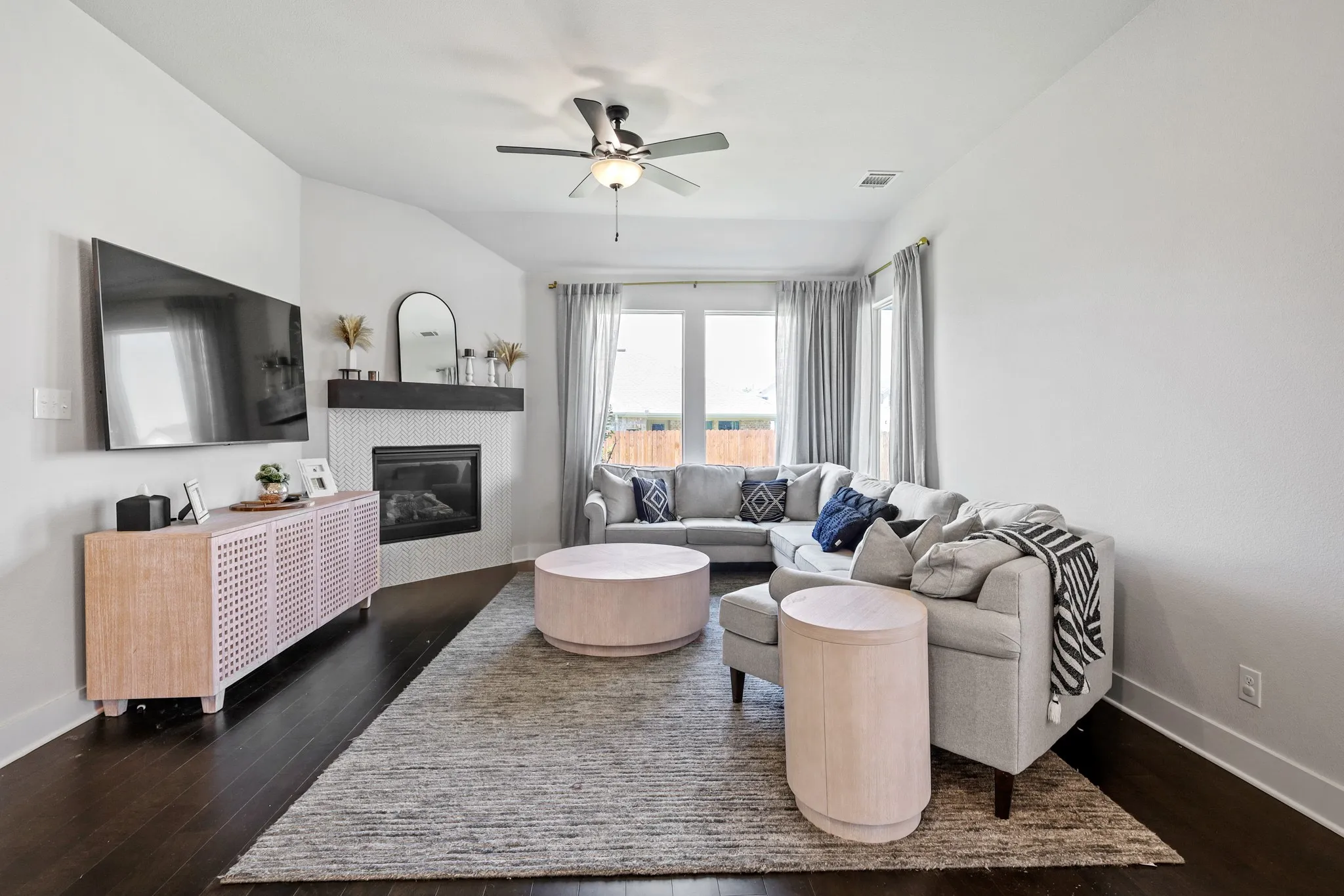 Living room with ceiling fan and dark hardwood / wood-style floors
