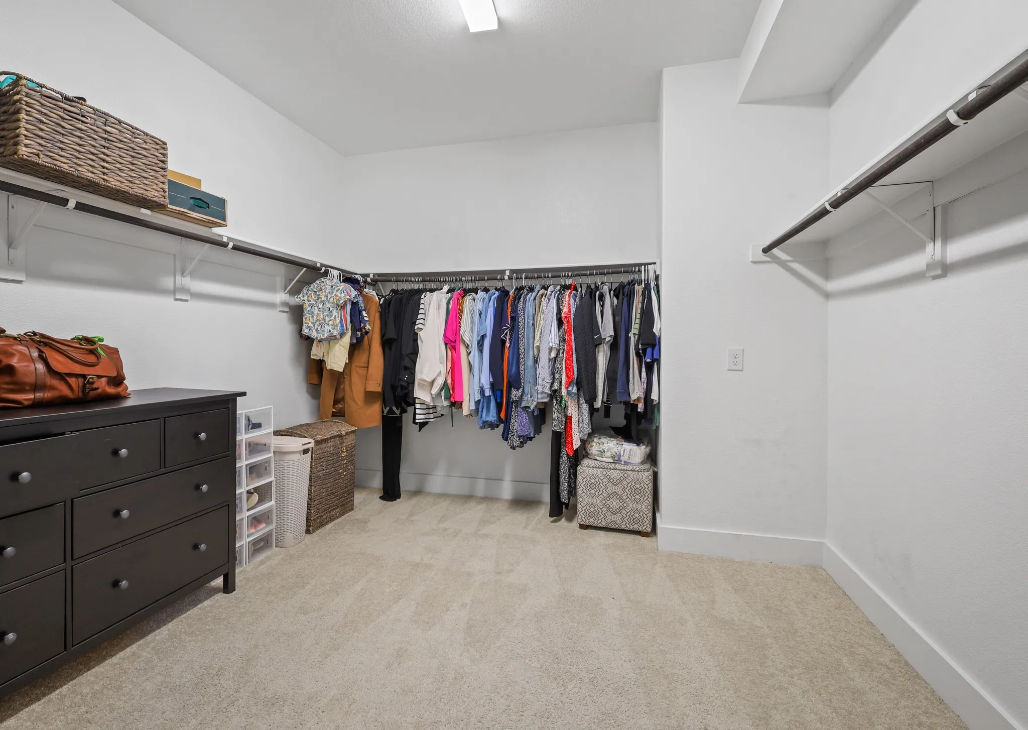 Spacious closet featuring light colored carpet
