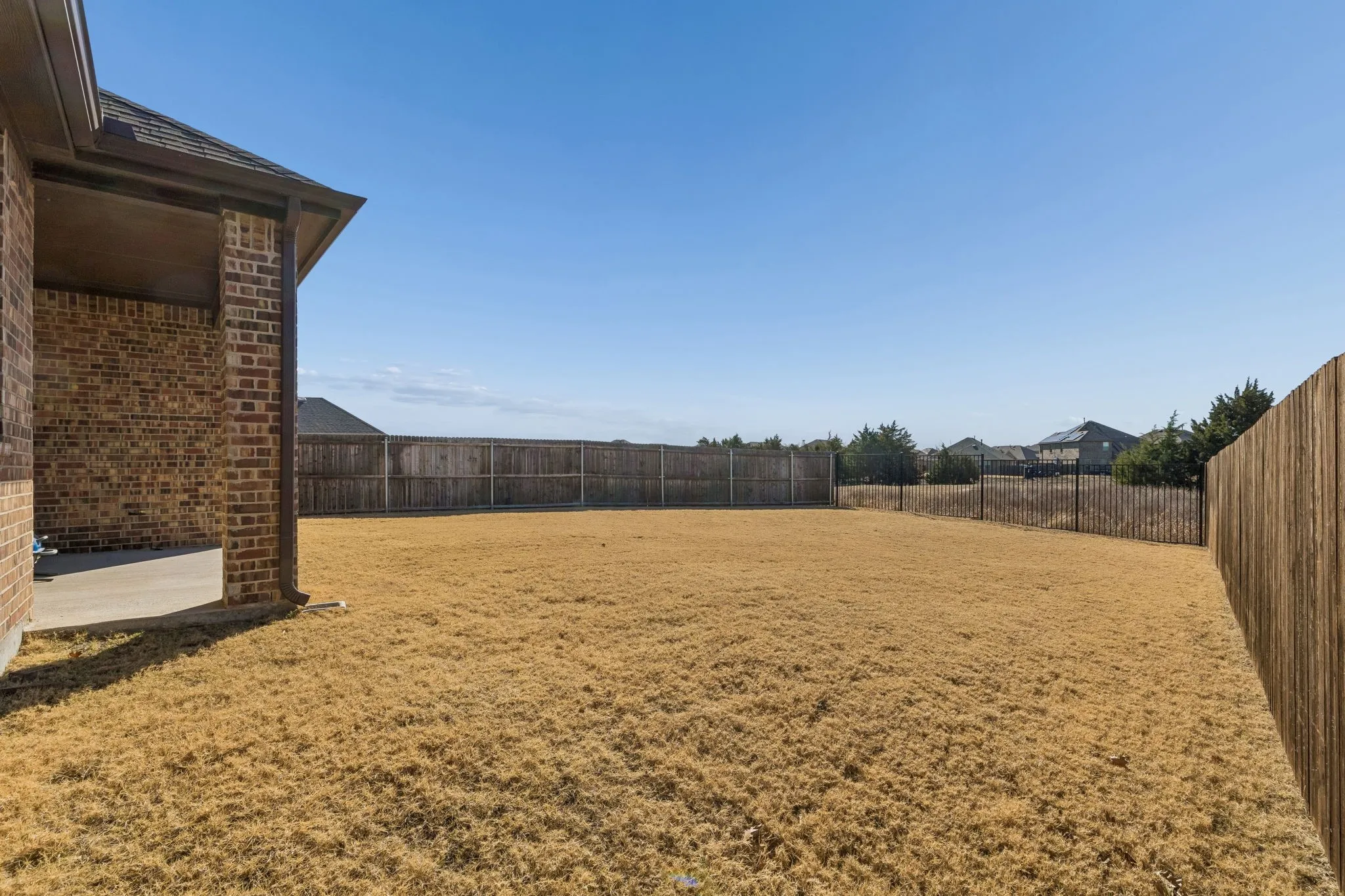 Fenced backyard with a patio area