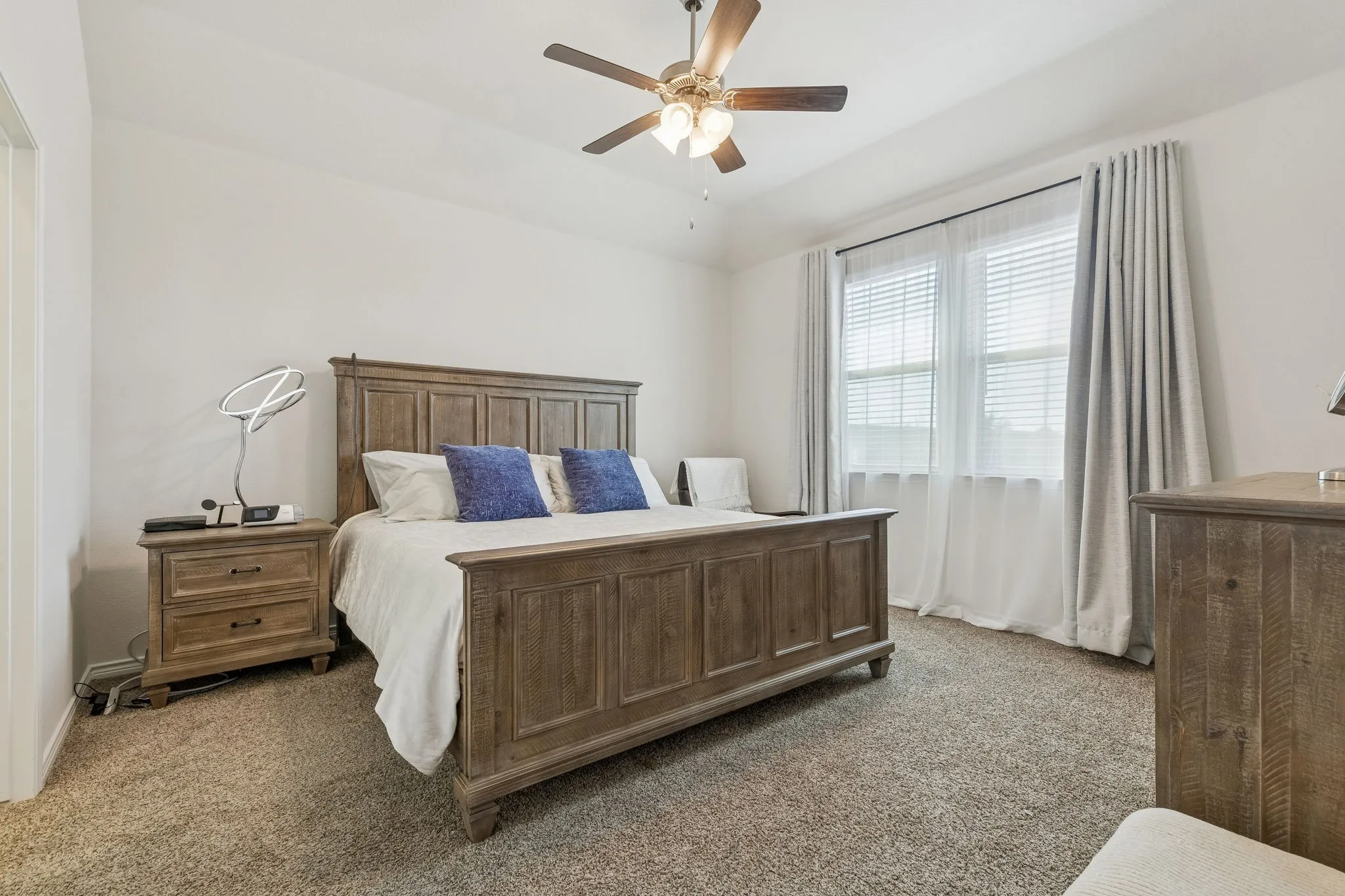 Carpeted bedroom featuring a ceiling fan and baseboards