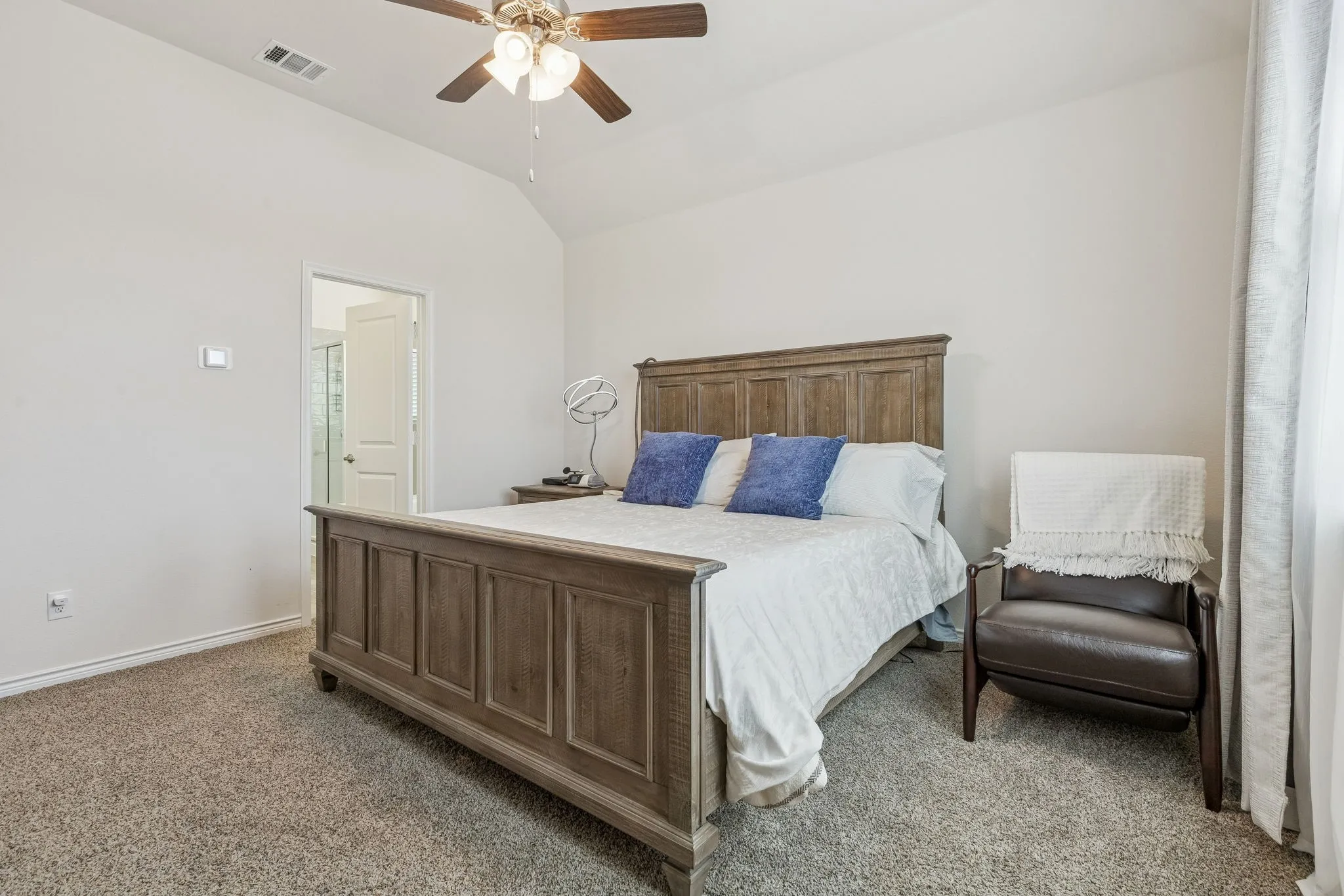 Bedroom with lofted ceiling, dark colored carpet, and ceiling fan