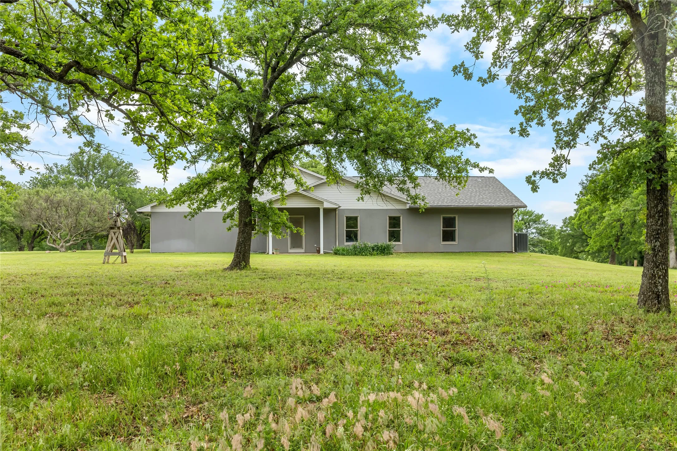 The property features a gray exterior with multiple windows and a covered porch