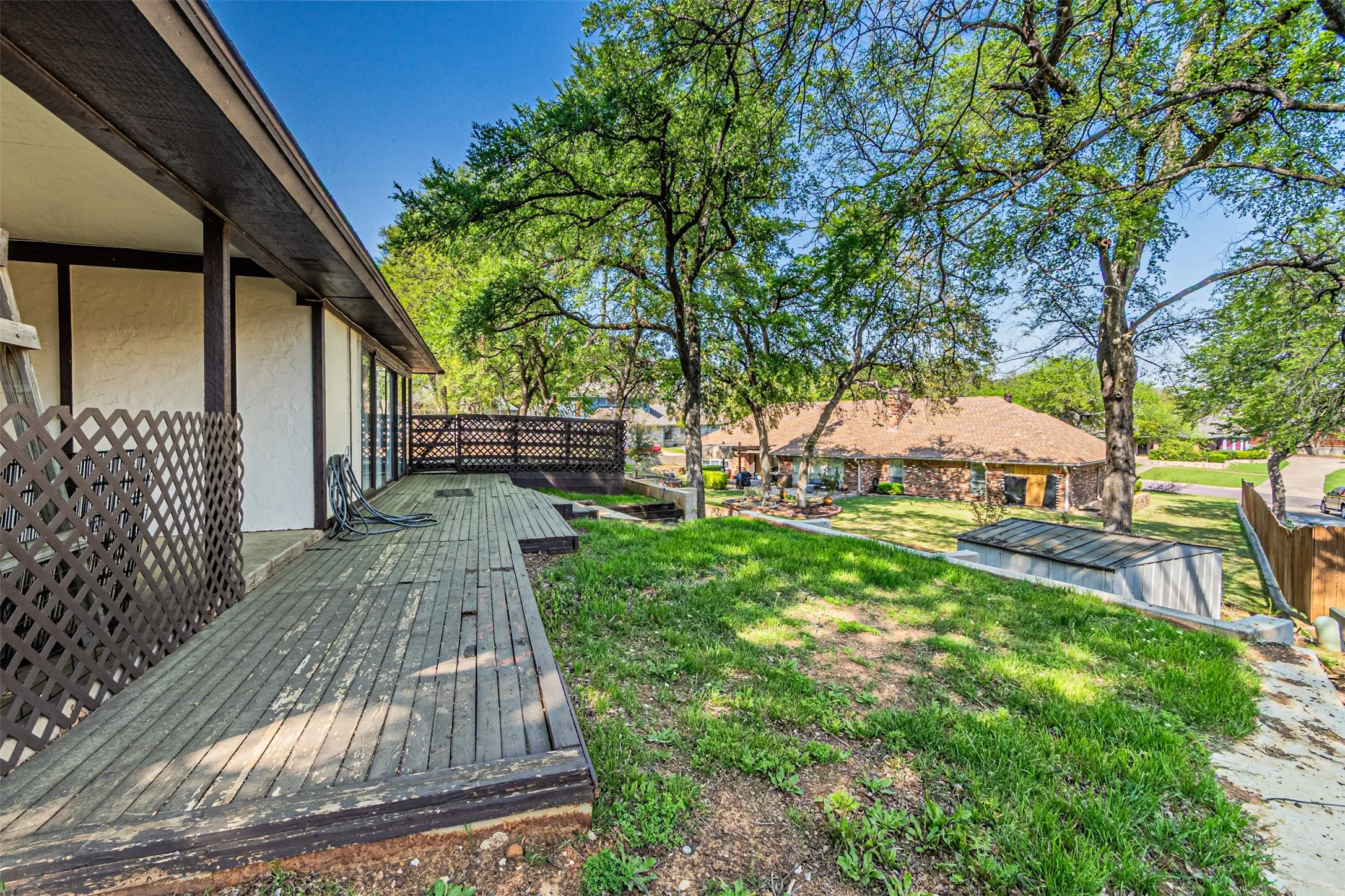 View of grassy yard featuring a wooden deck