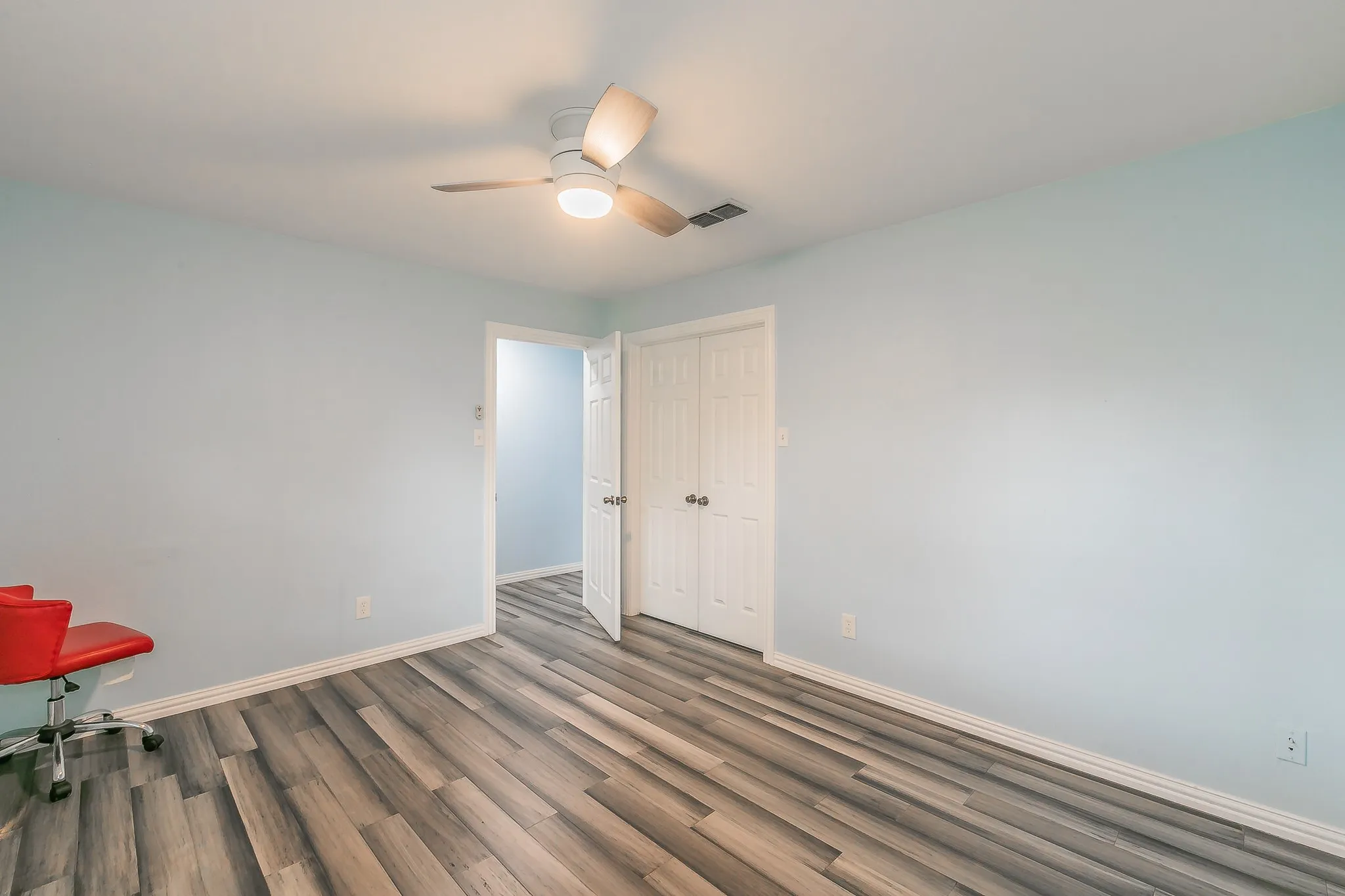 Empty room with wood finished floors and a ceiling fan