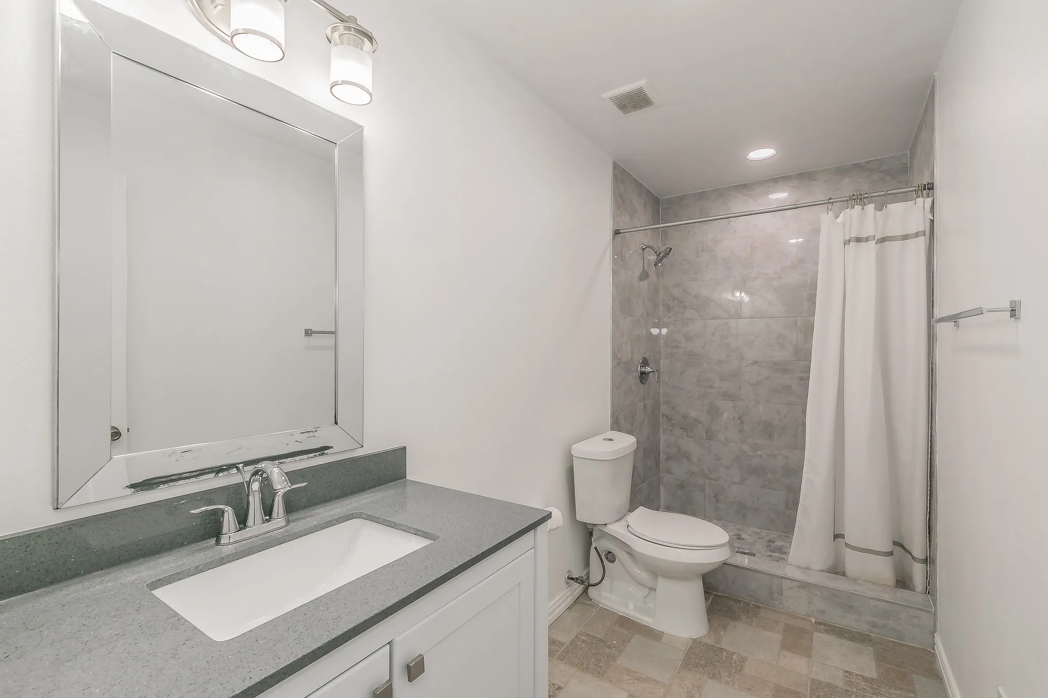 Full bathroom with vanity and tiled shower