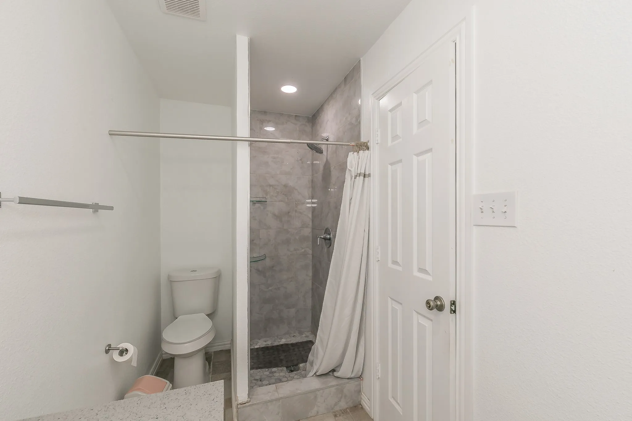 Full bath featuring a stall shower and tile patterned flooring