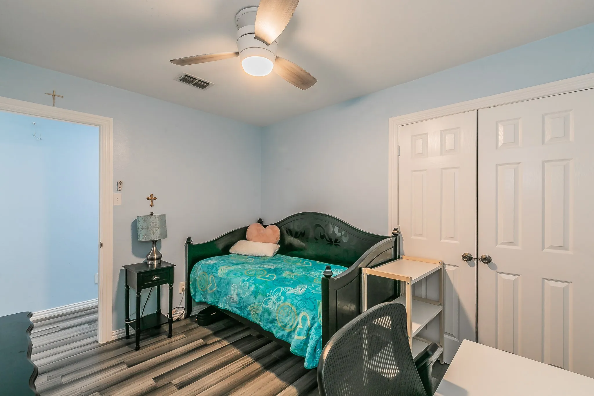 Bedroom with wood finished floors, ceiling fan, and a closet