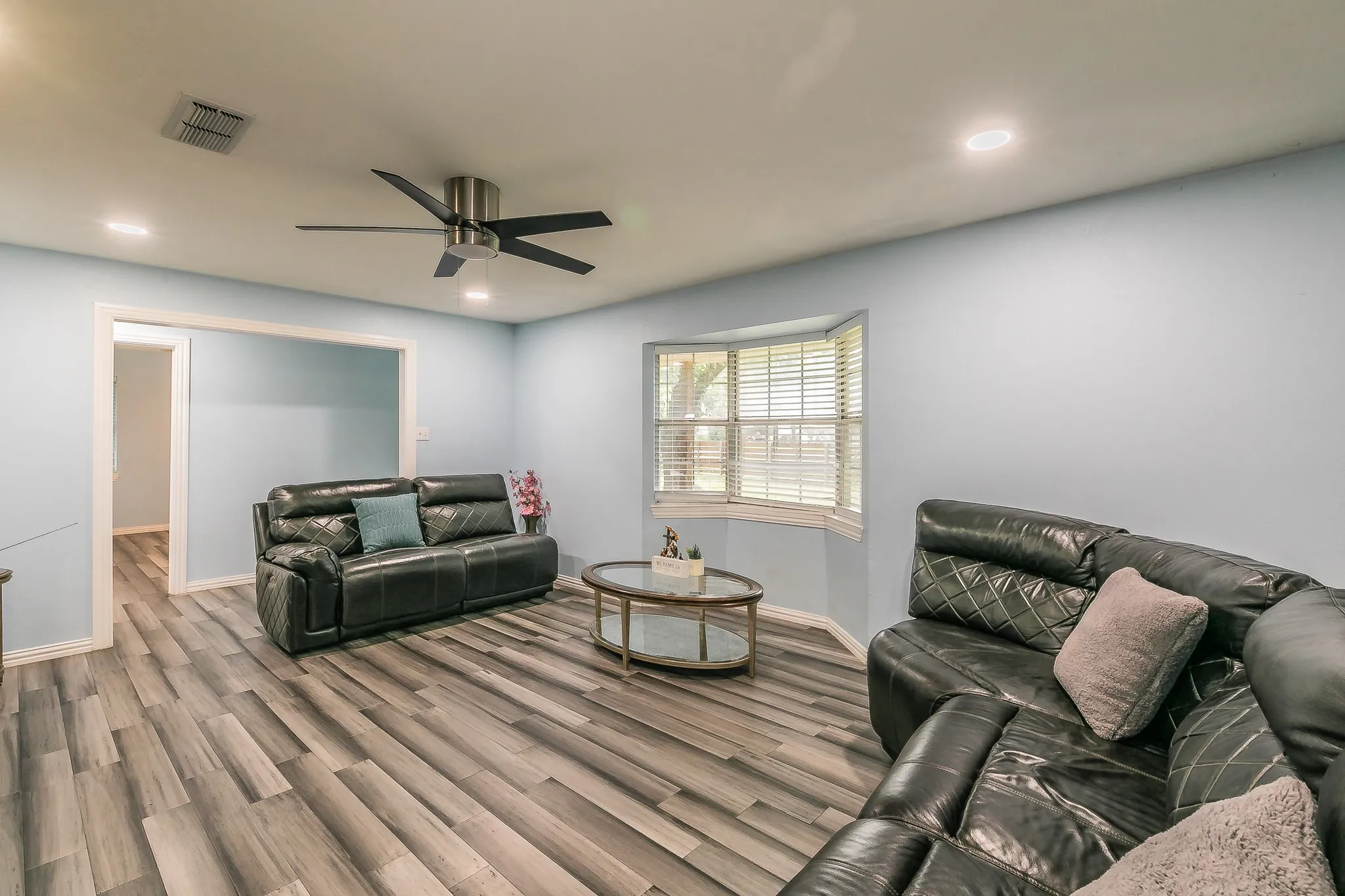 Living room with wood finished floors, a ceiling fan, and recessed lighting