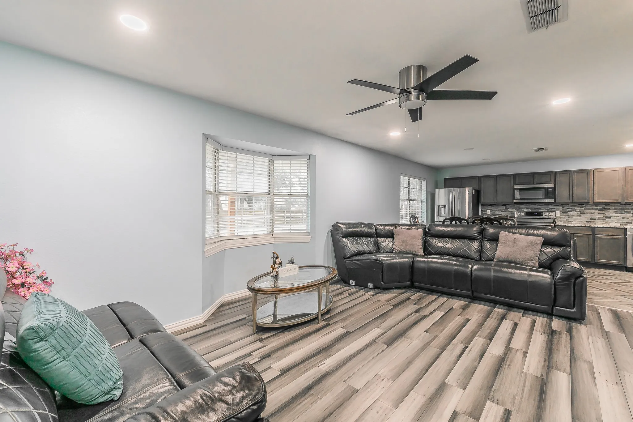 Living area with a ceiling fan, recessed lighting, and light wood-style flooring