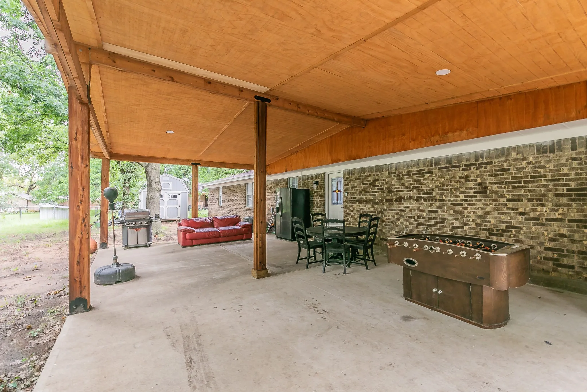 View of patio with a shed, a grill, and an outdoor hangout area