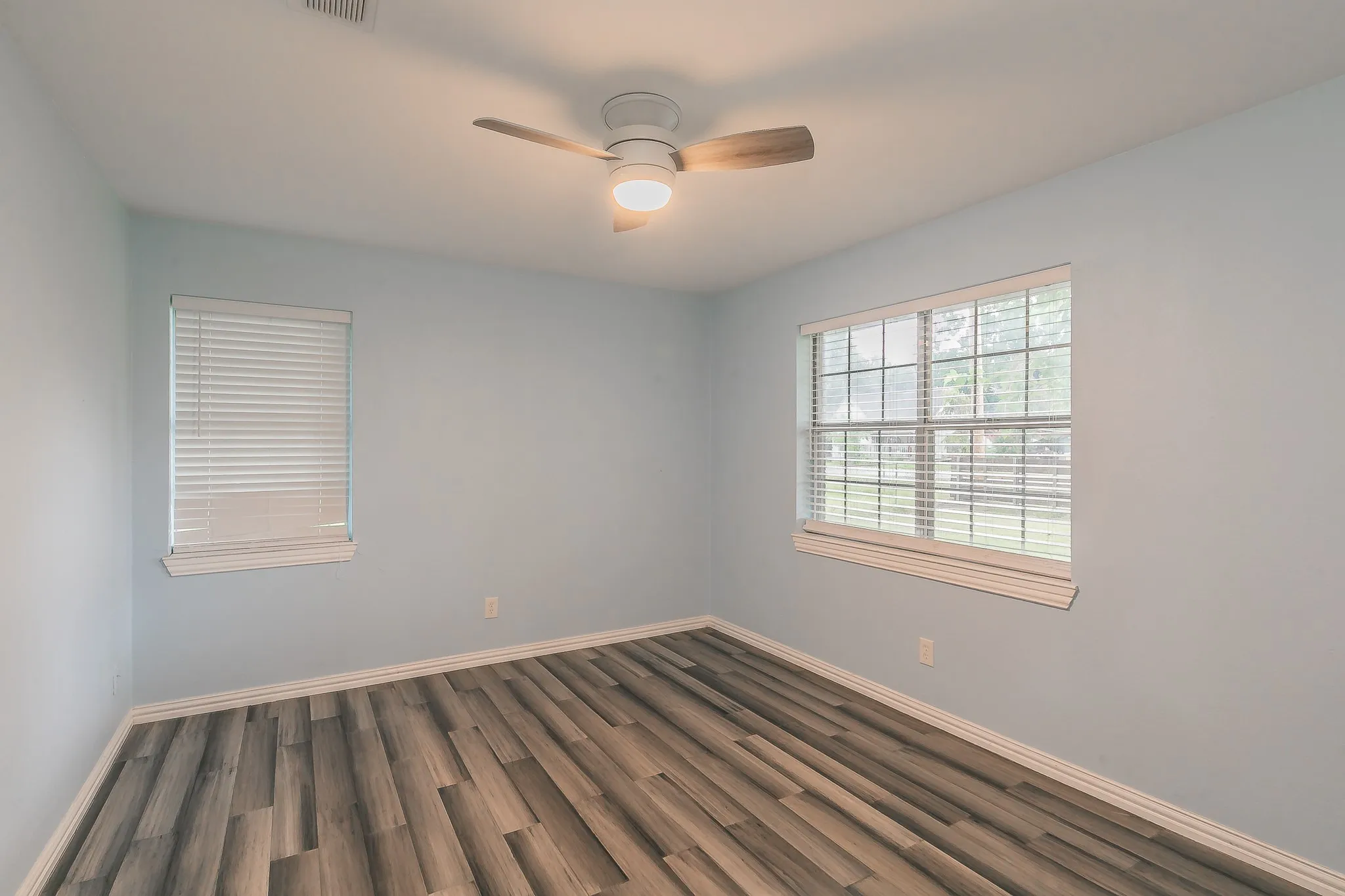 Spare room with dark wood-type flooring and ceiling fan