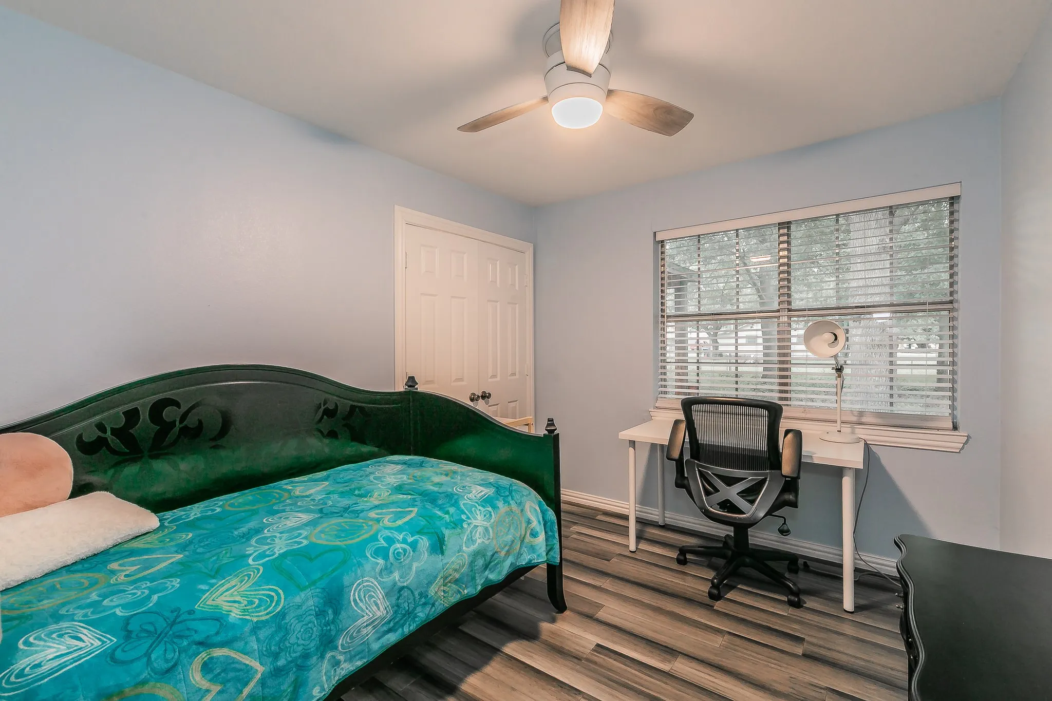 Bedroom with wood finished floors, ceiling fan, and a closet
