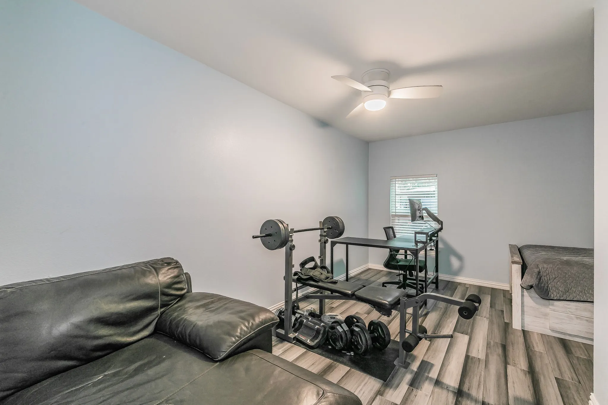 Exercise area featuring wood finished floors and ceiling fan