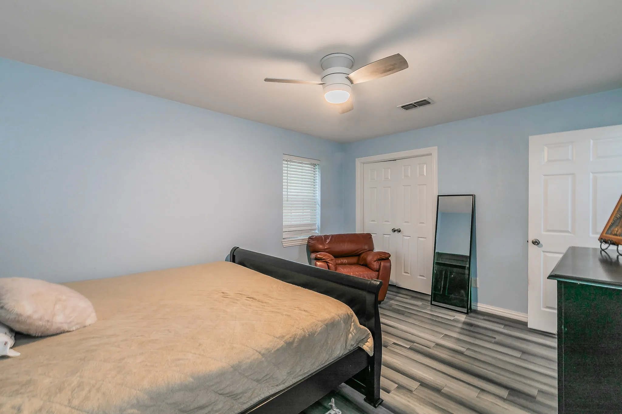 Bedroom with wood finished floors, a closet, and ceiling fan