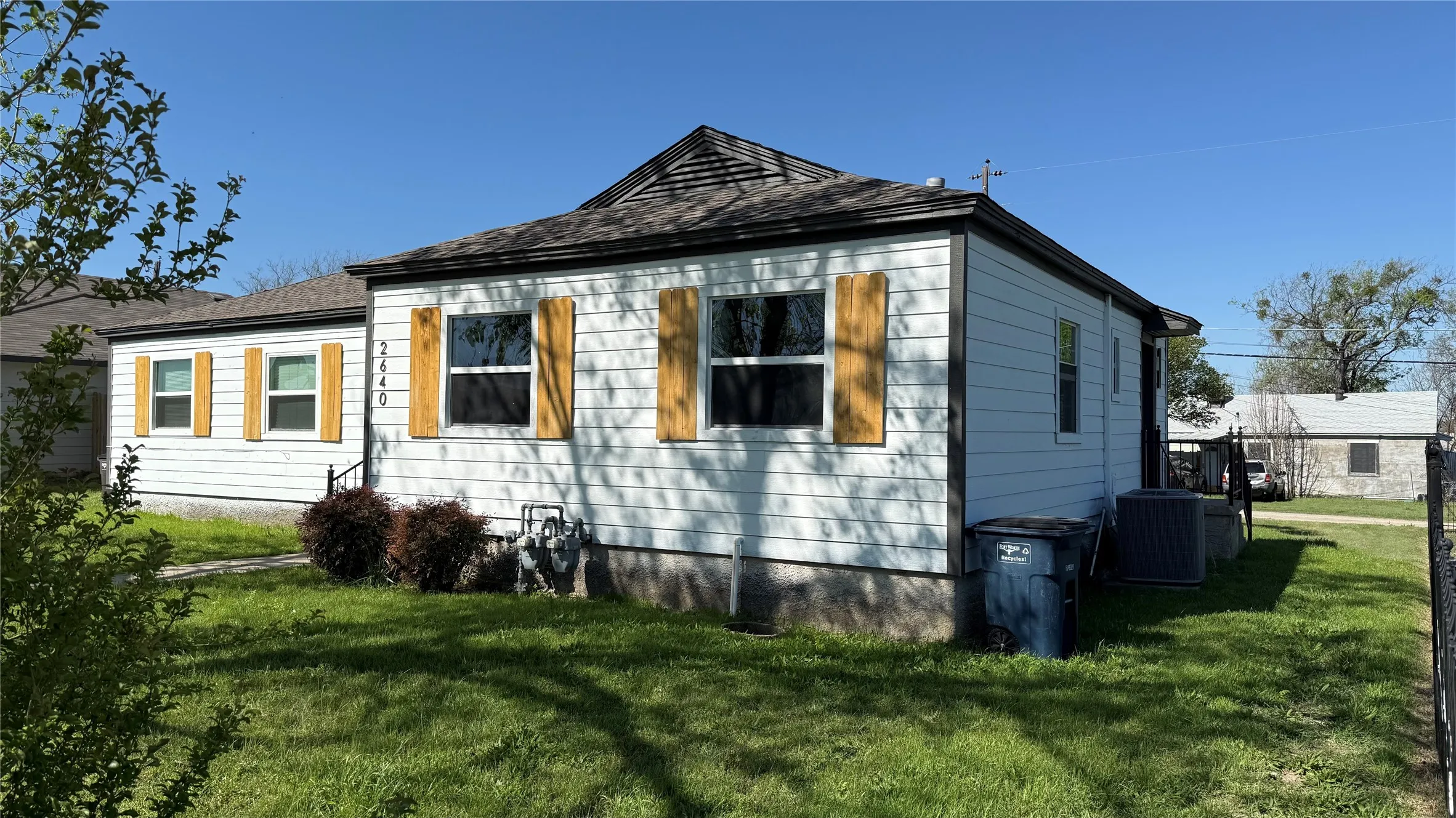 View of side of home featuring a lawn and a cooling unit