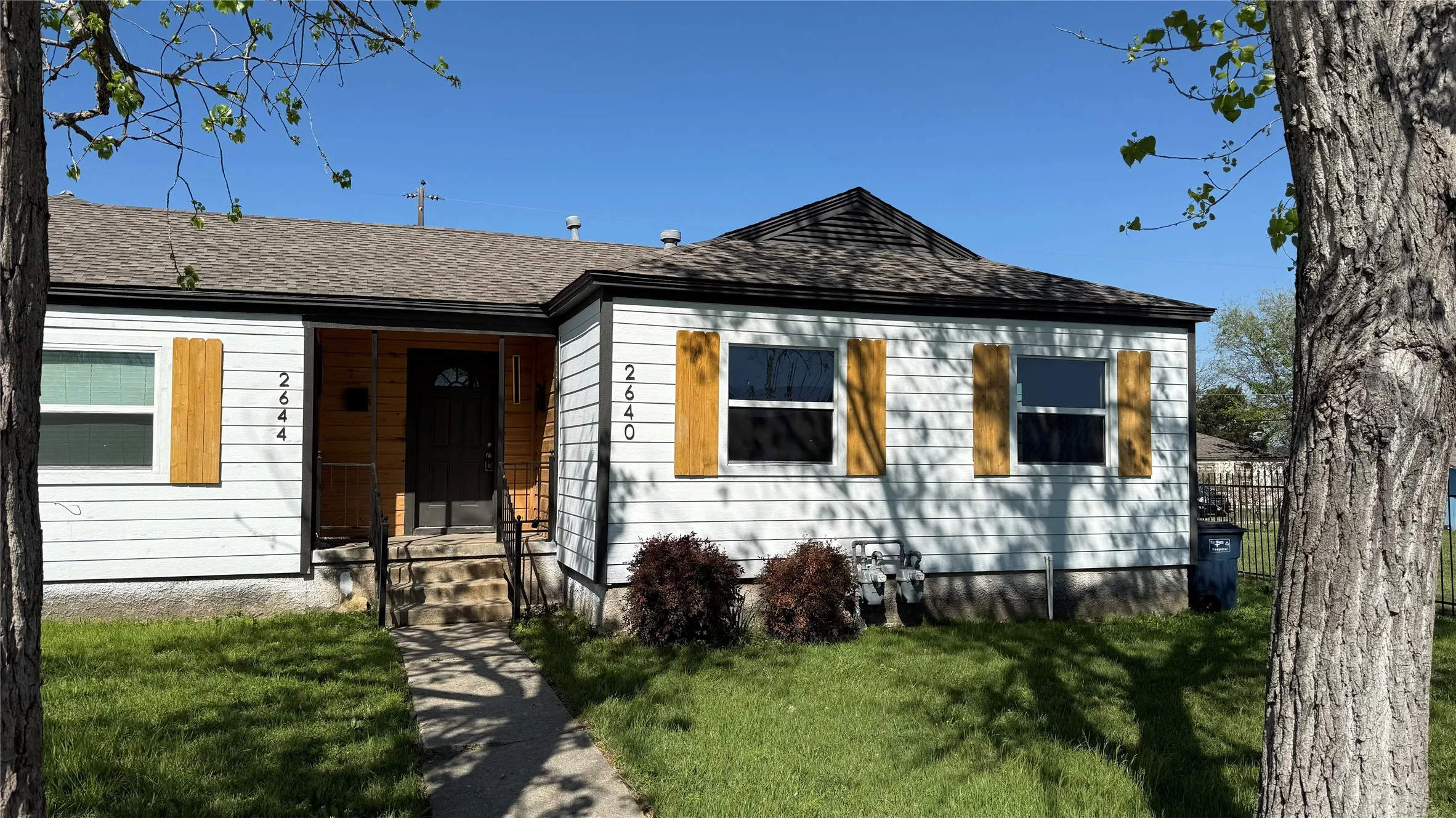 View of front of house with a front lawn and roof with shingles