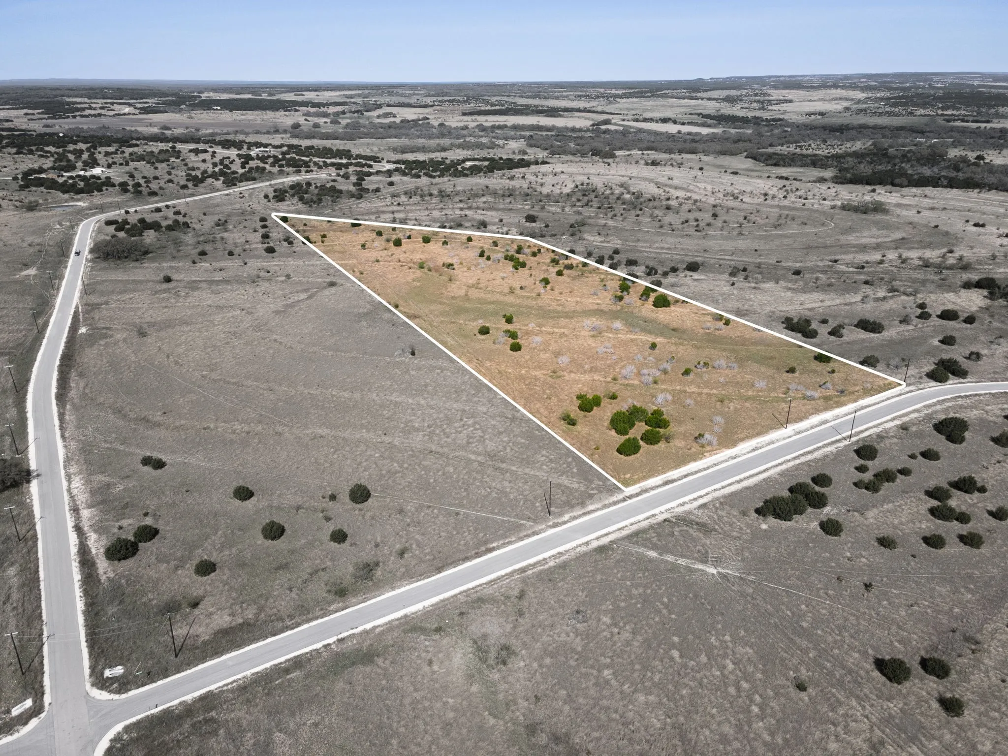 Aerial overview of property's location with property parcel outlined and rural landscape