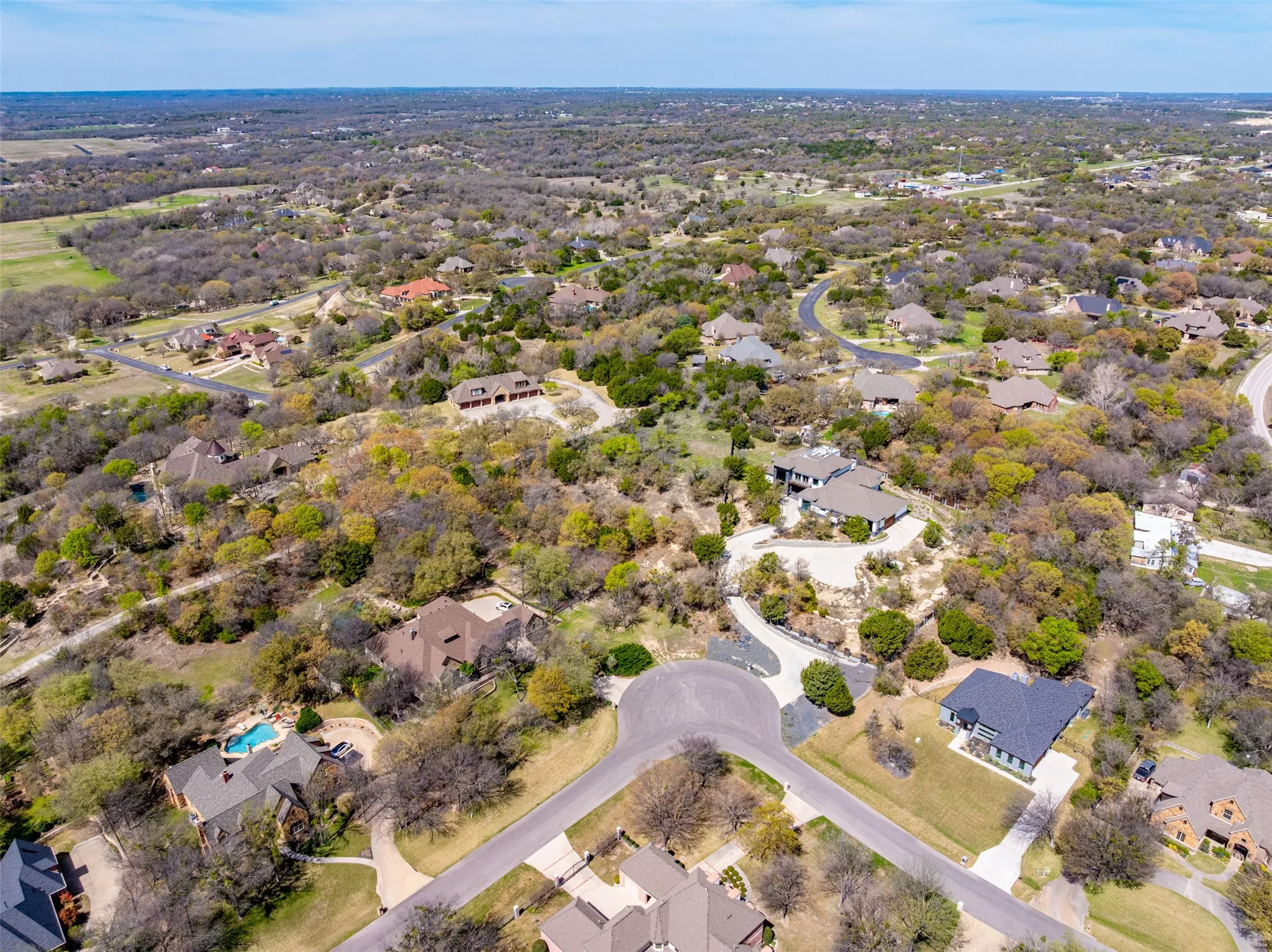 Aerial view of property and surrounding area with nearby suburban area