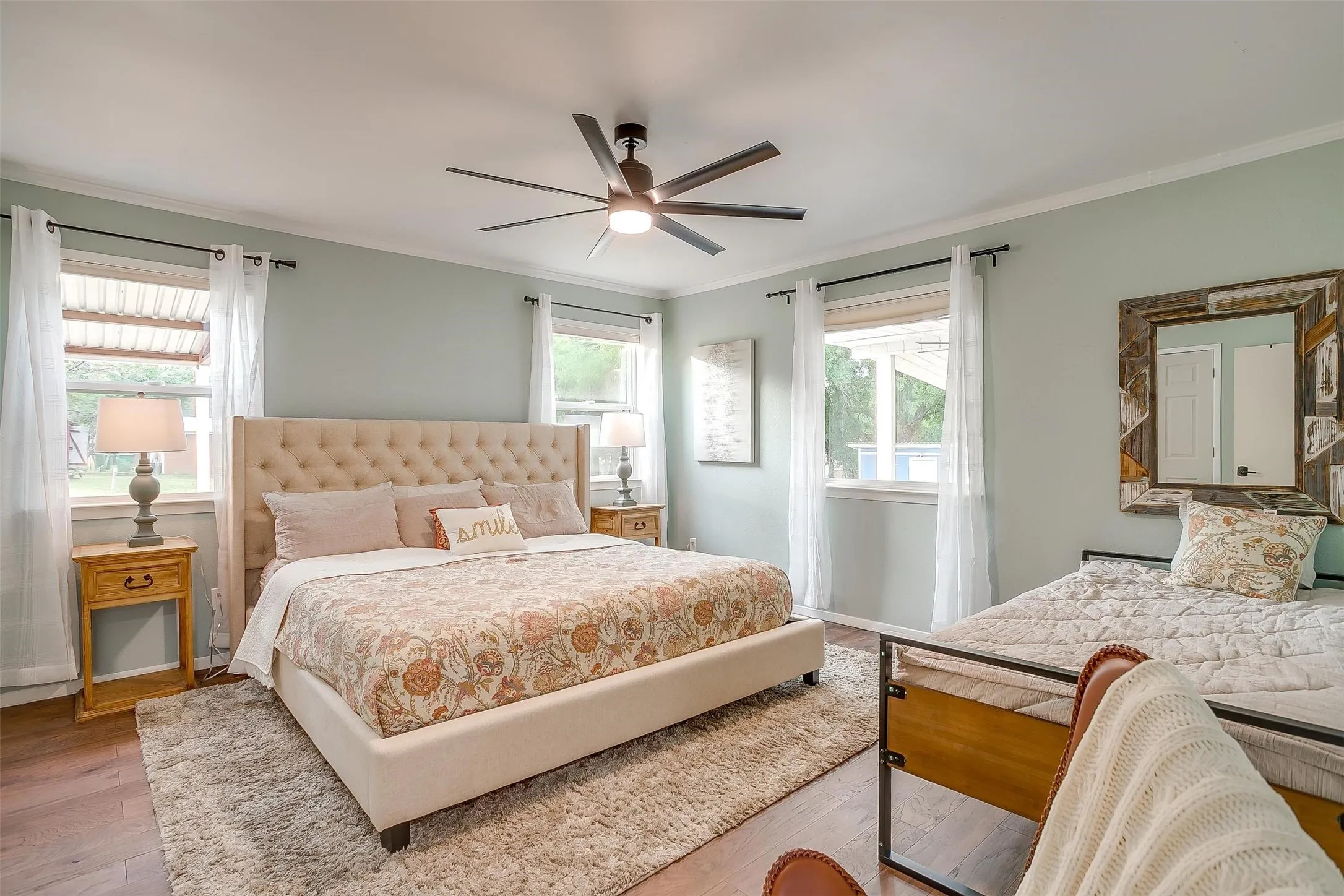 Bedroom featuring wood finished floors, ornamental molding, and a ceiling fan