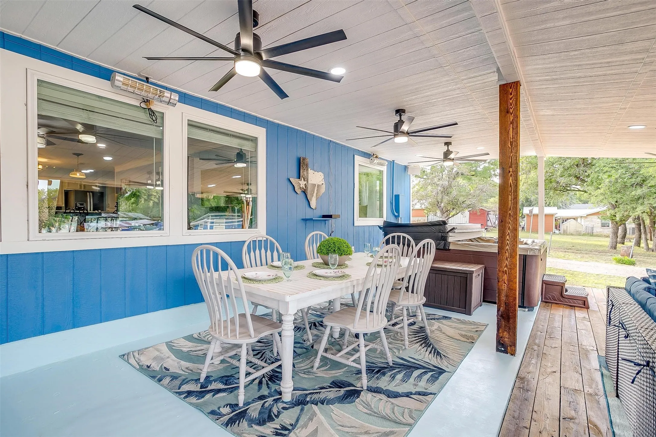 View of patio with outdoor dining area, ceiling fan, and a wooden deck