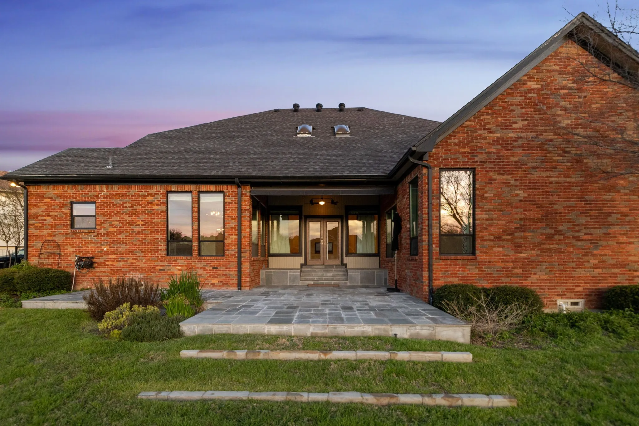 Back of house featuring french doors, a patio area, and brick siding