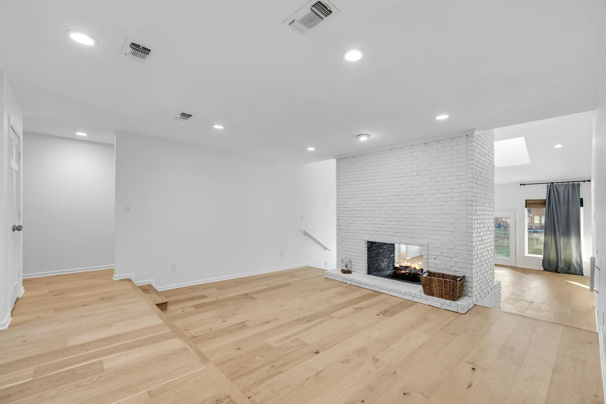 Unfurnished living room featuring light wood-style floors, a fireplace, and recessed lighting