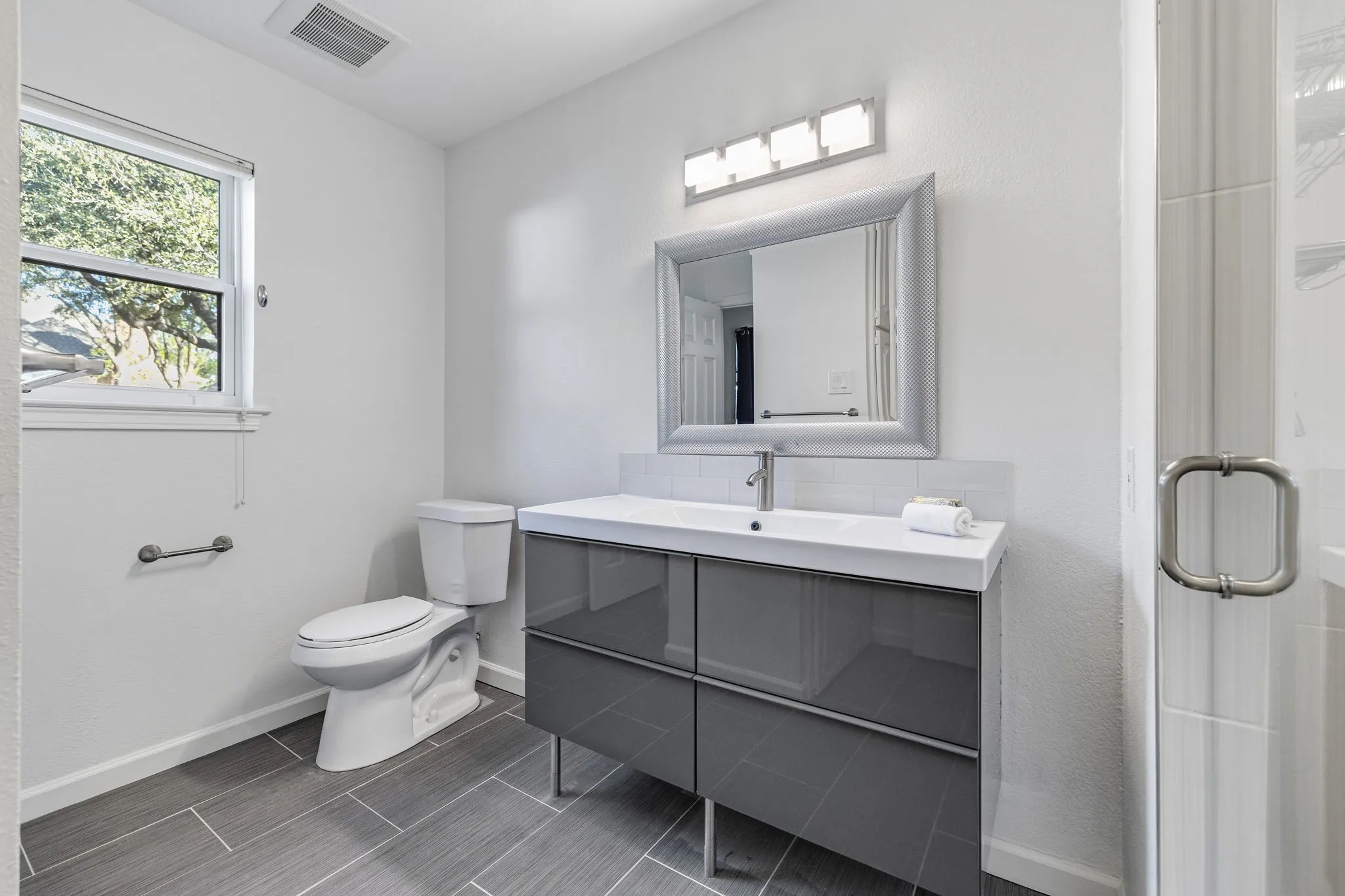 Full bath featuring vanity, a stall shower, and tasteful backsplash