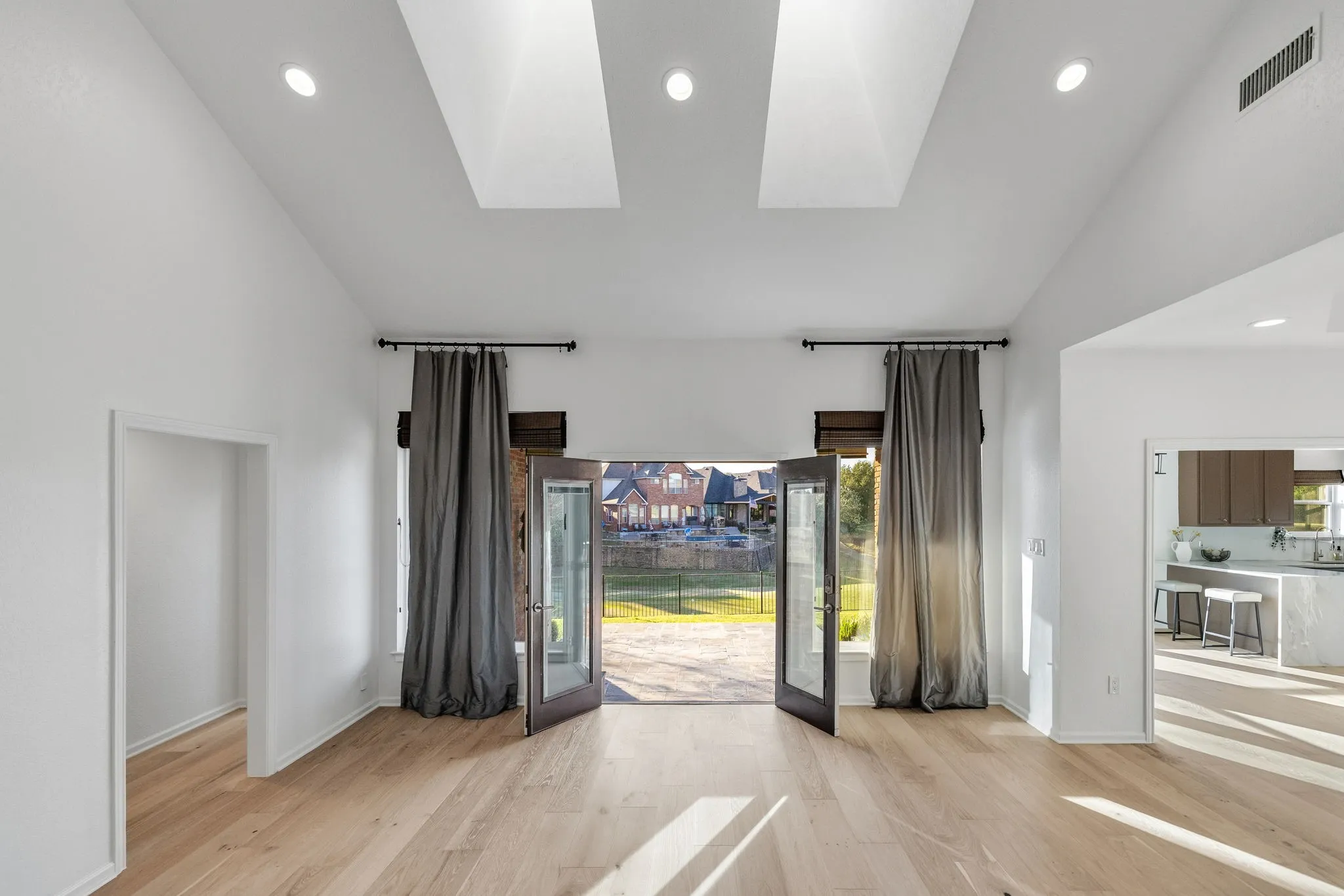 Spare room with vaulted ceiling, recessed lighting, a skylight, light wood-style floors, and healthy amount of natural light