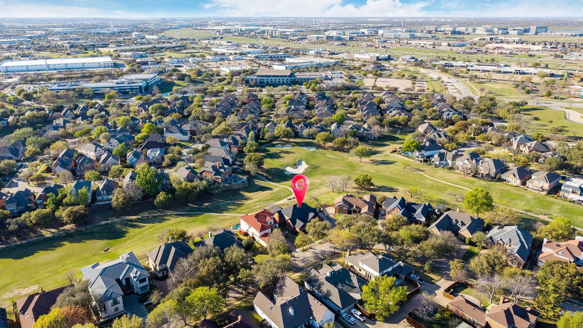 Aerial view of property's location featuring a local golf course and nearby suburban area