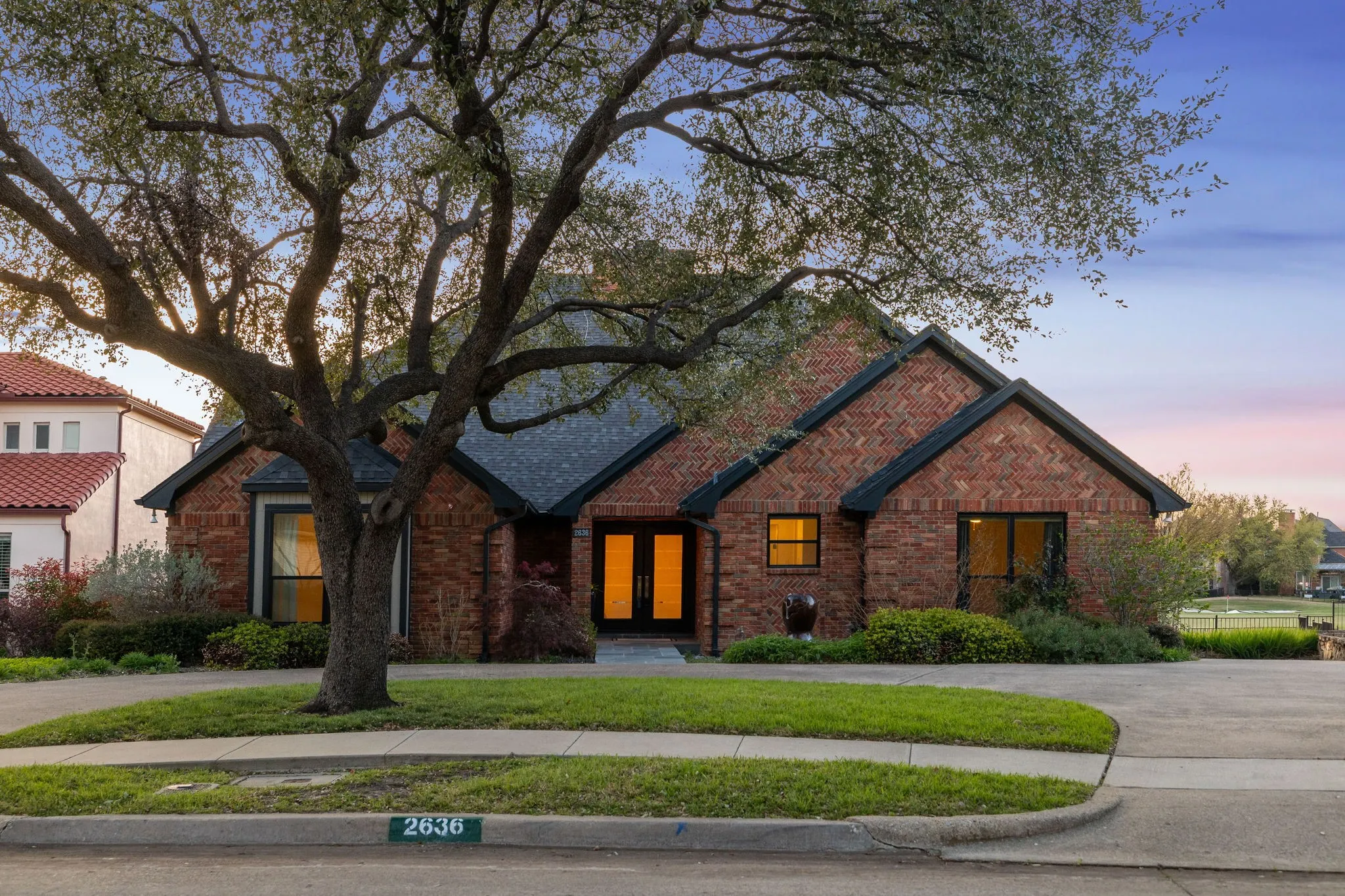 View of front of property with french doors, brick siding, and a yard