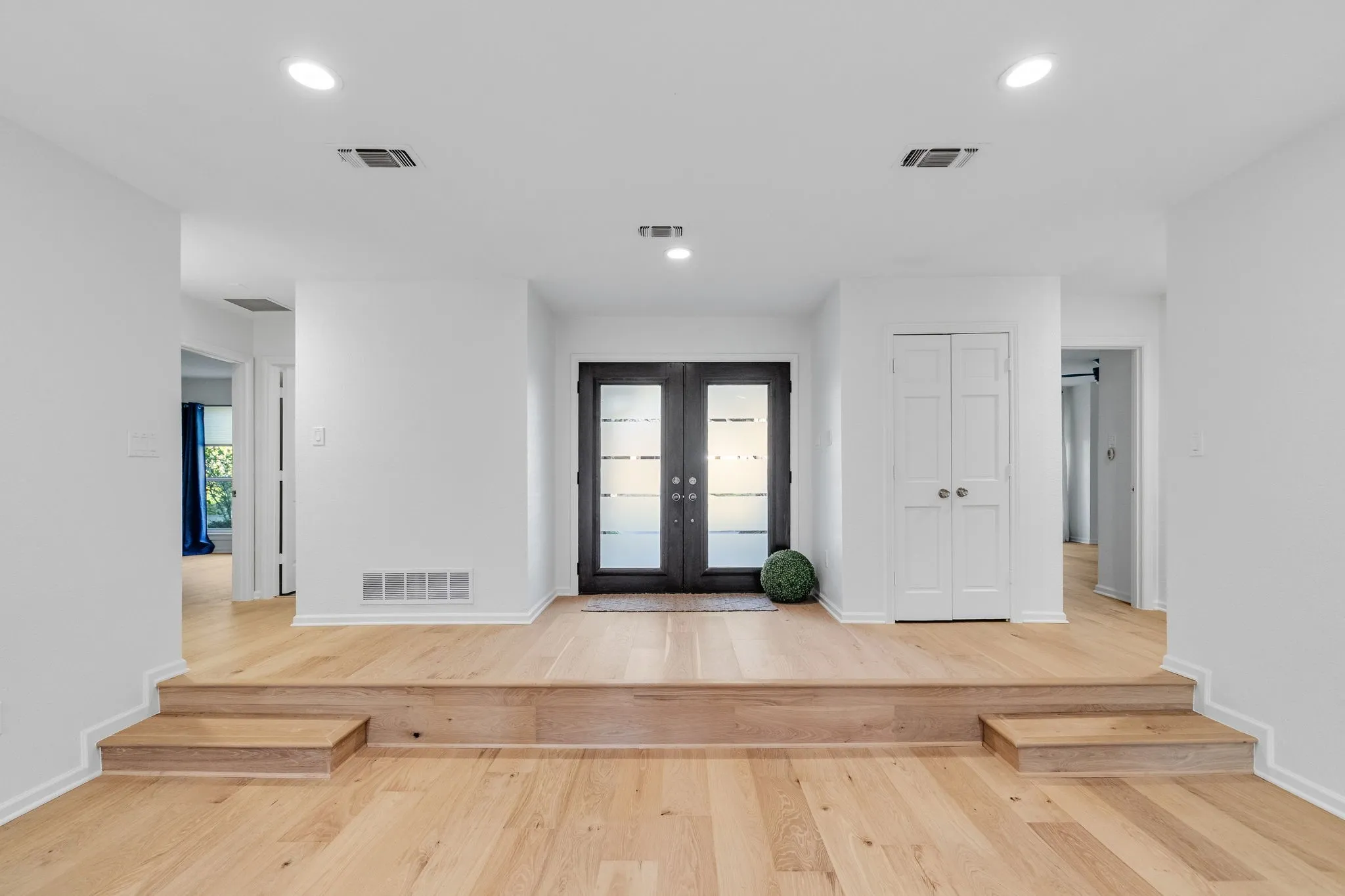 Entryway with french doors, light wood-style flooring, and recessed lighting